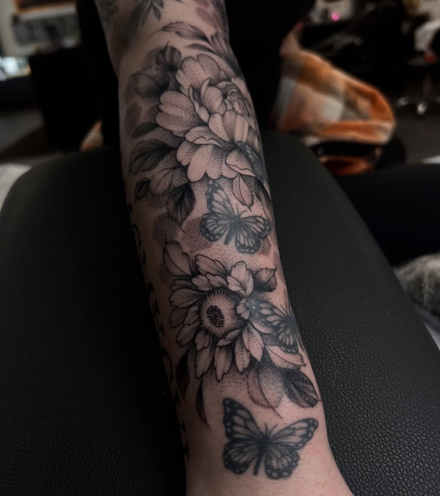 Flowers and butterflies dotwork tattoo on the forearm by Chloe