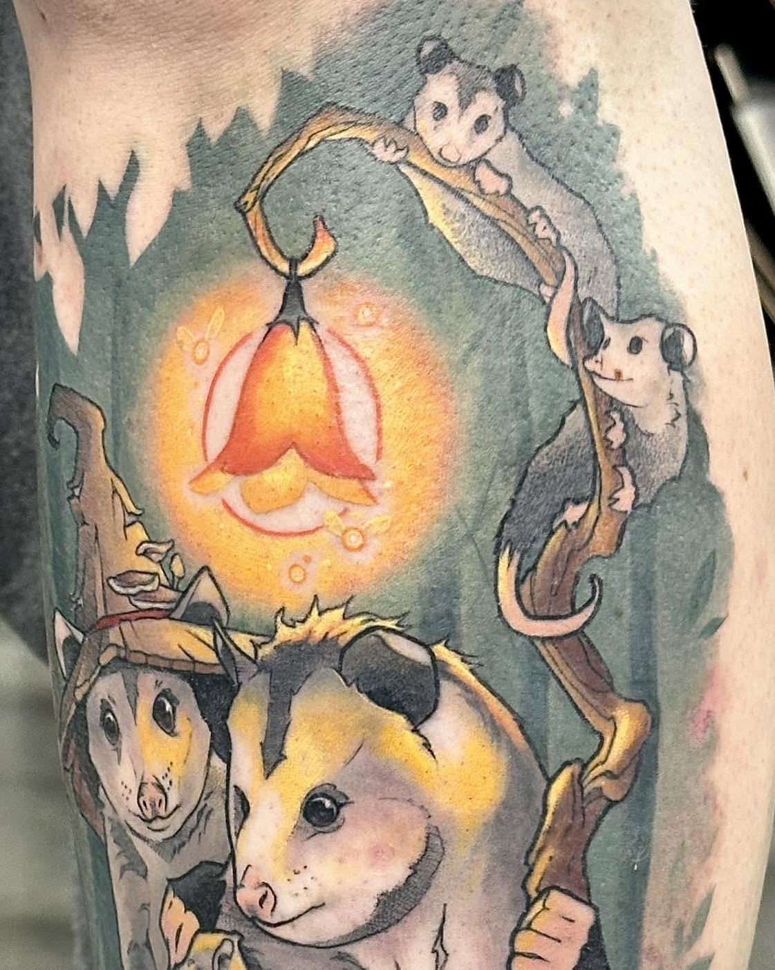 Possums and lantern watercolor tattoo on the forearm by Harper Clark