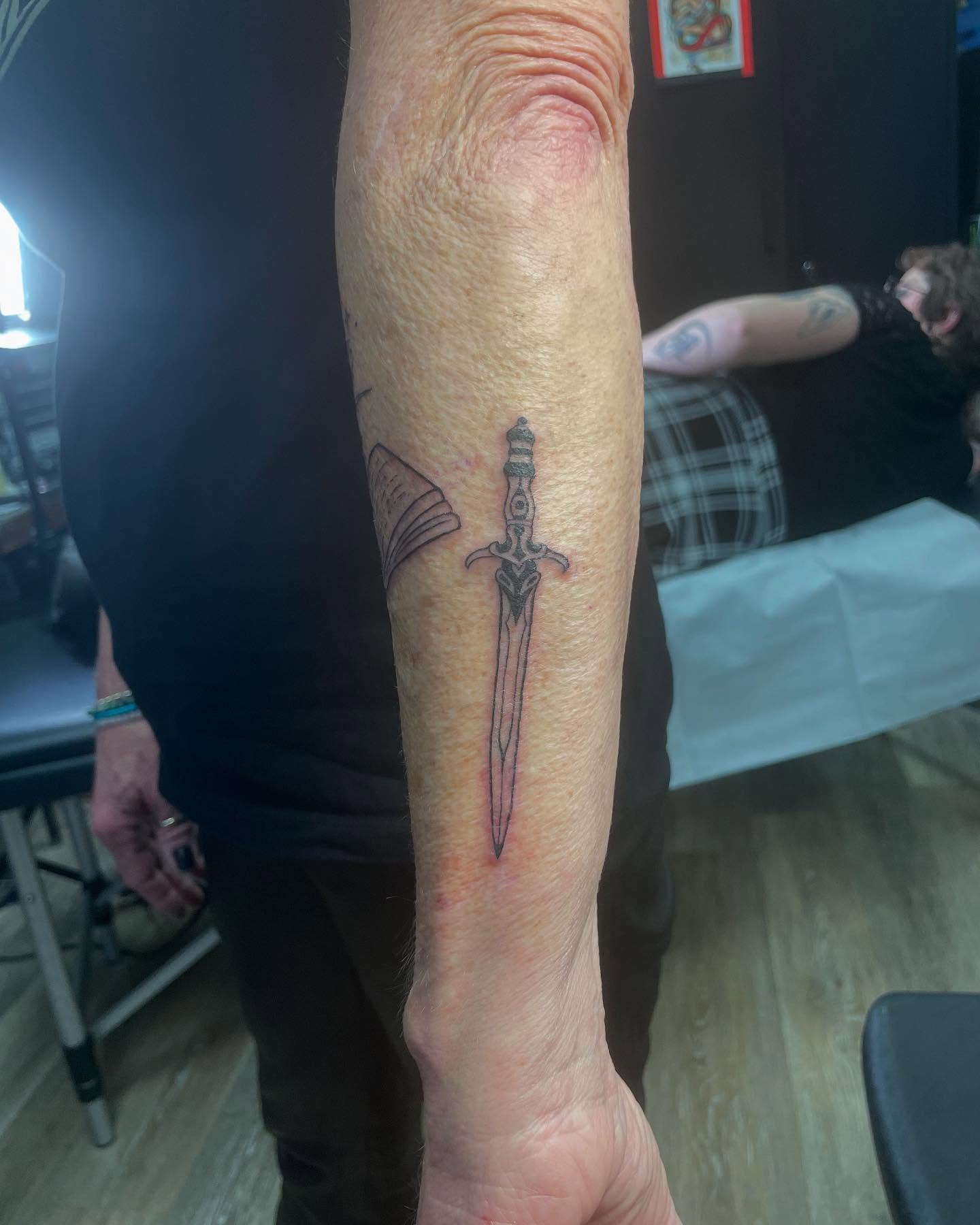 Sword black and grey tattoo on the forearm by Classy Fucking Lady Tattooer