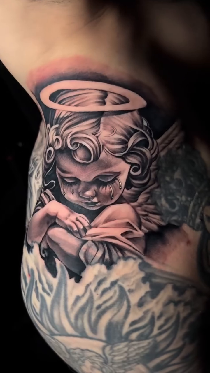 Cherub with halo realism tattoo by Brayan Molina