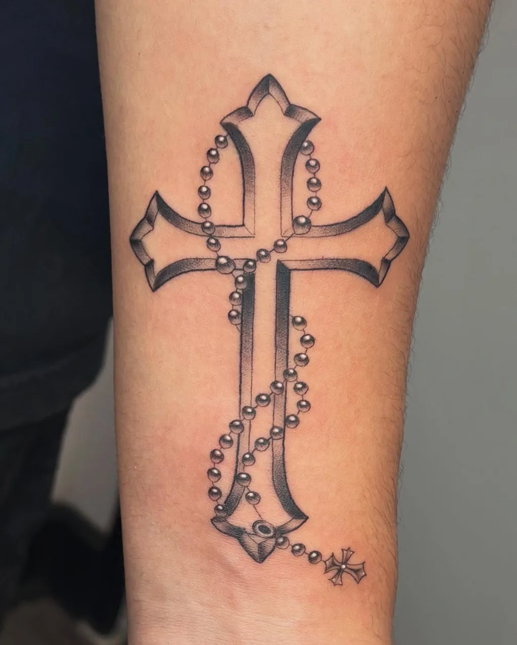 Cross with rosary black and grey tattoo on the forearm by Savana ☆