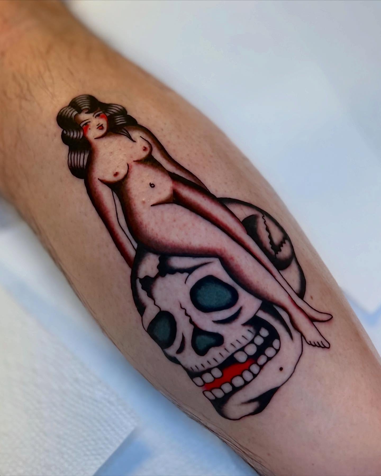 Nude woman on skull American traditional tattoo on the forearm by Syd Sayyah