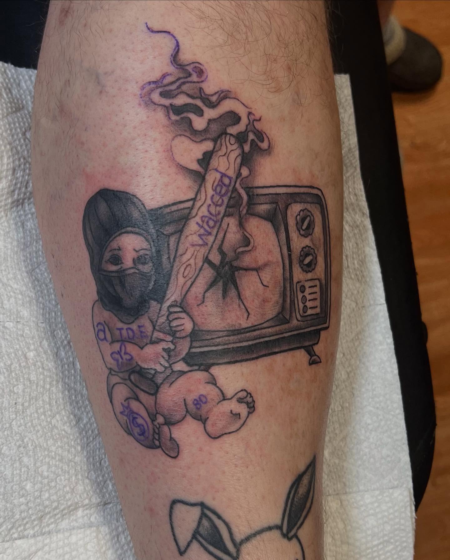 Tv, ninja, cigarette black and grey tattoo on the forearm by Katie Sayre