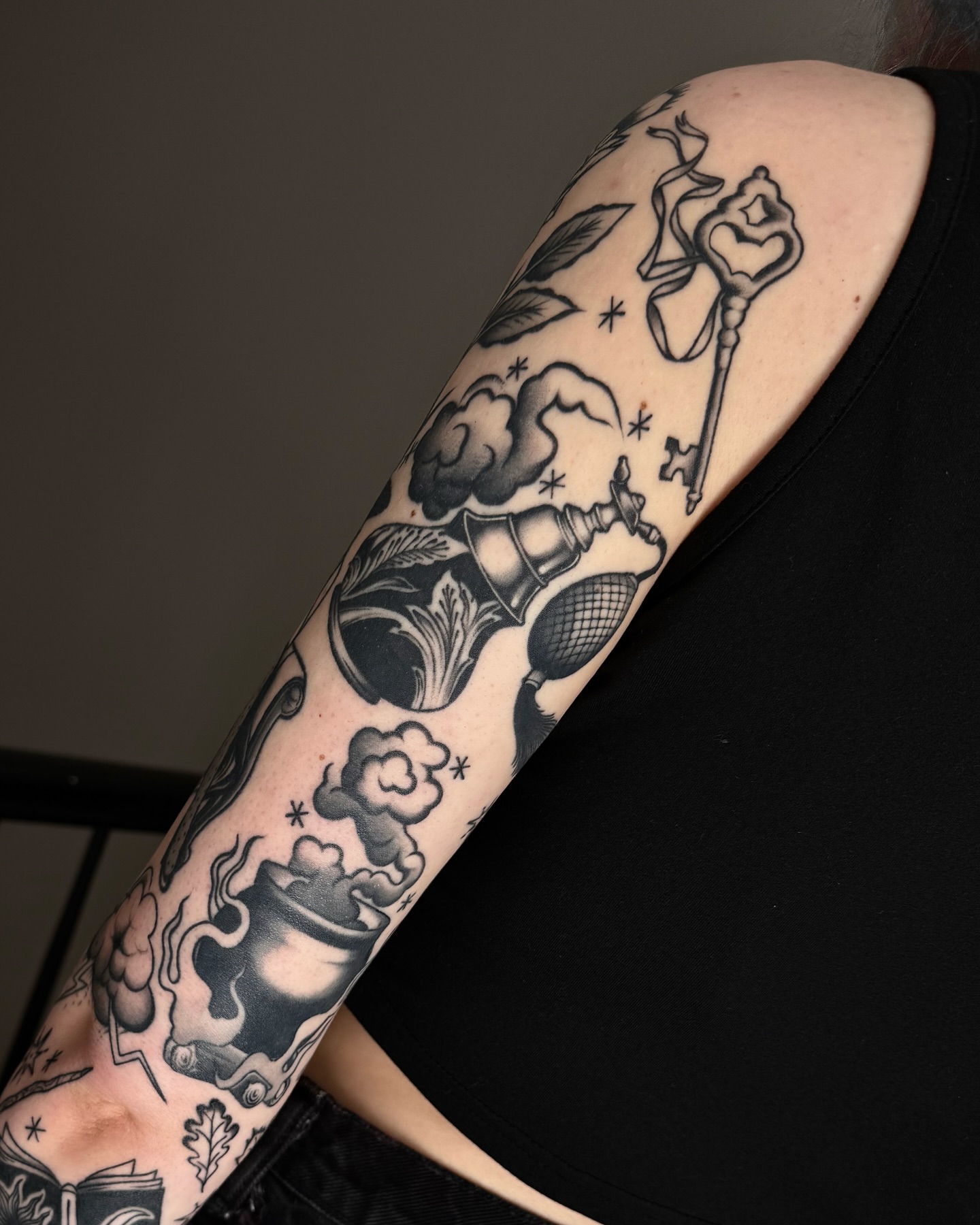 Smoke, key, book, vase, leaf black and grey tattoo on the forearm by 𝒟𝑜𝓃𝓃𝒶 𝒥 ࿏ Portland Tattoo Artist