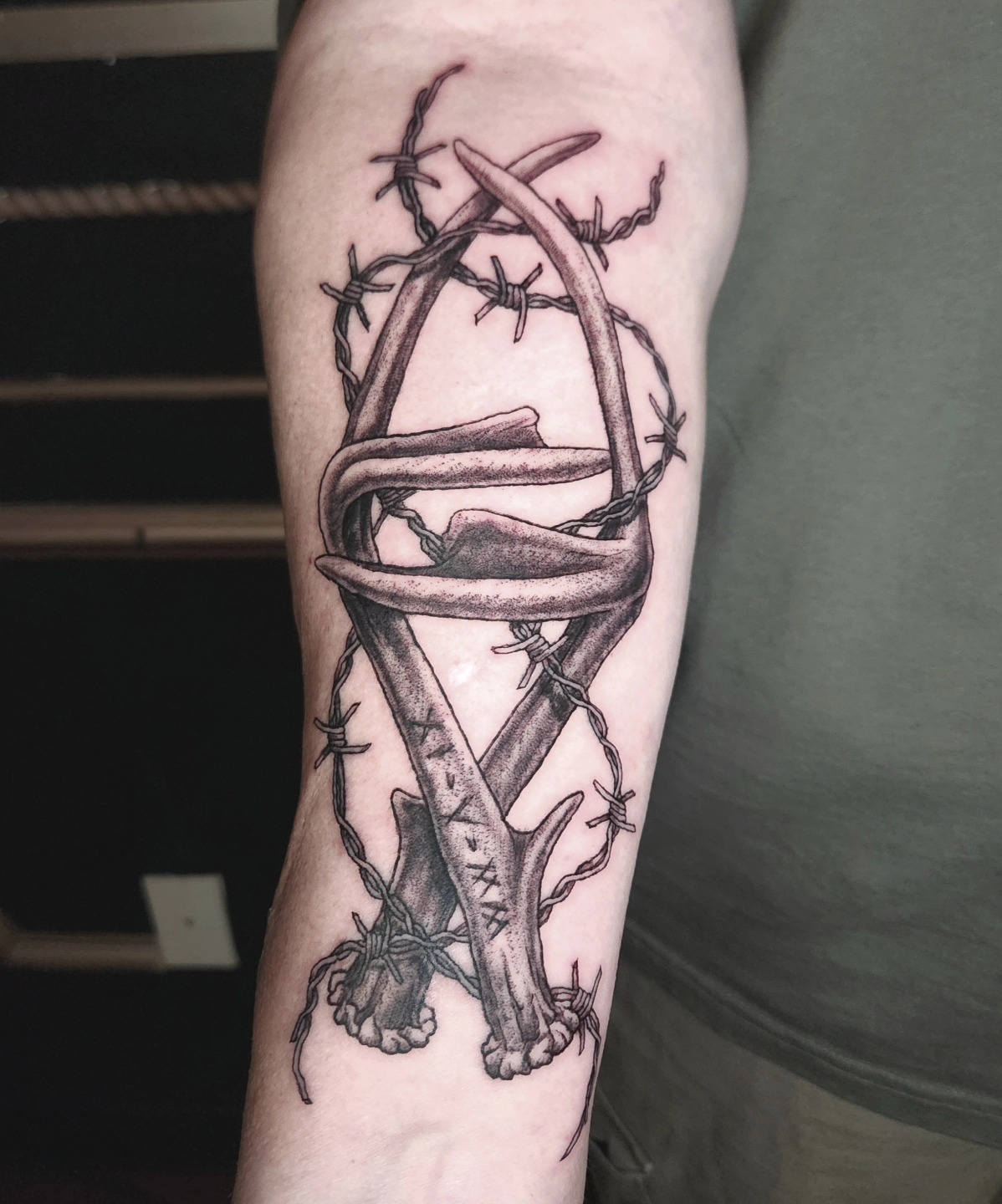 Barbed wire and bones realism tattoo on the forearm by Perry