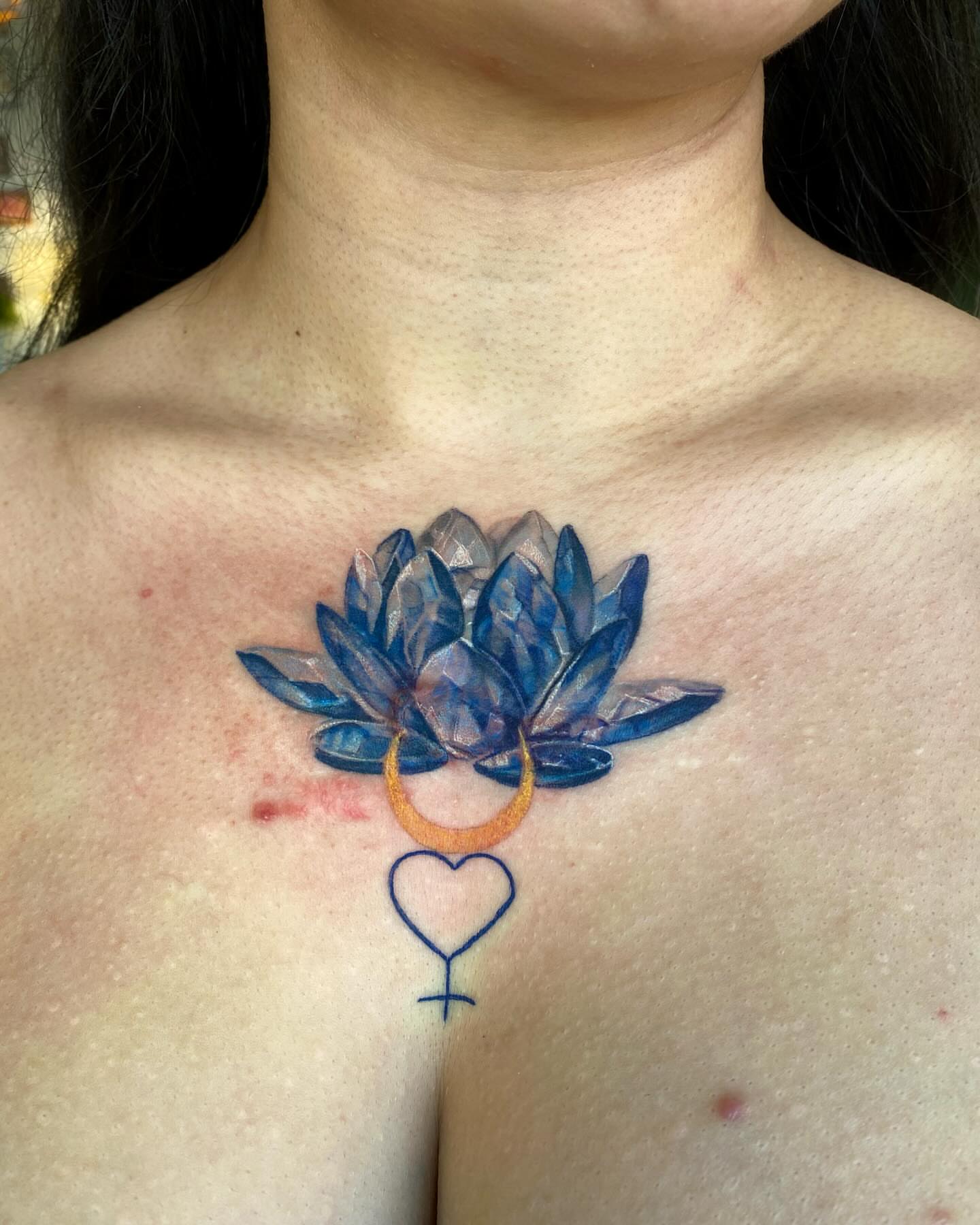 Lotus flower geometric tattoo on the chest by Amber Miracle