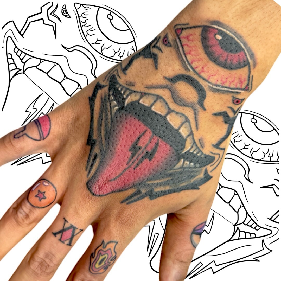 Grinning skull American traditional tattoo on the hand by Victor Campos