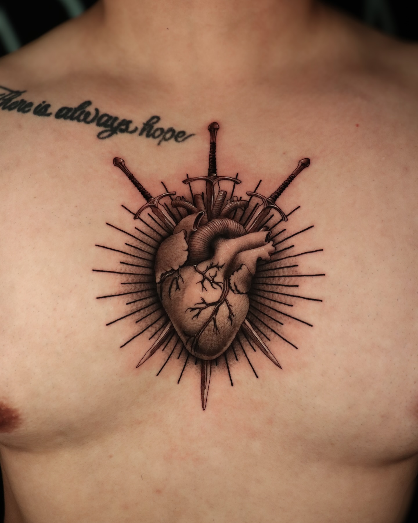 Heart with swords realism tattoo on the chest by Jeff Reindel