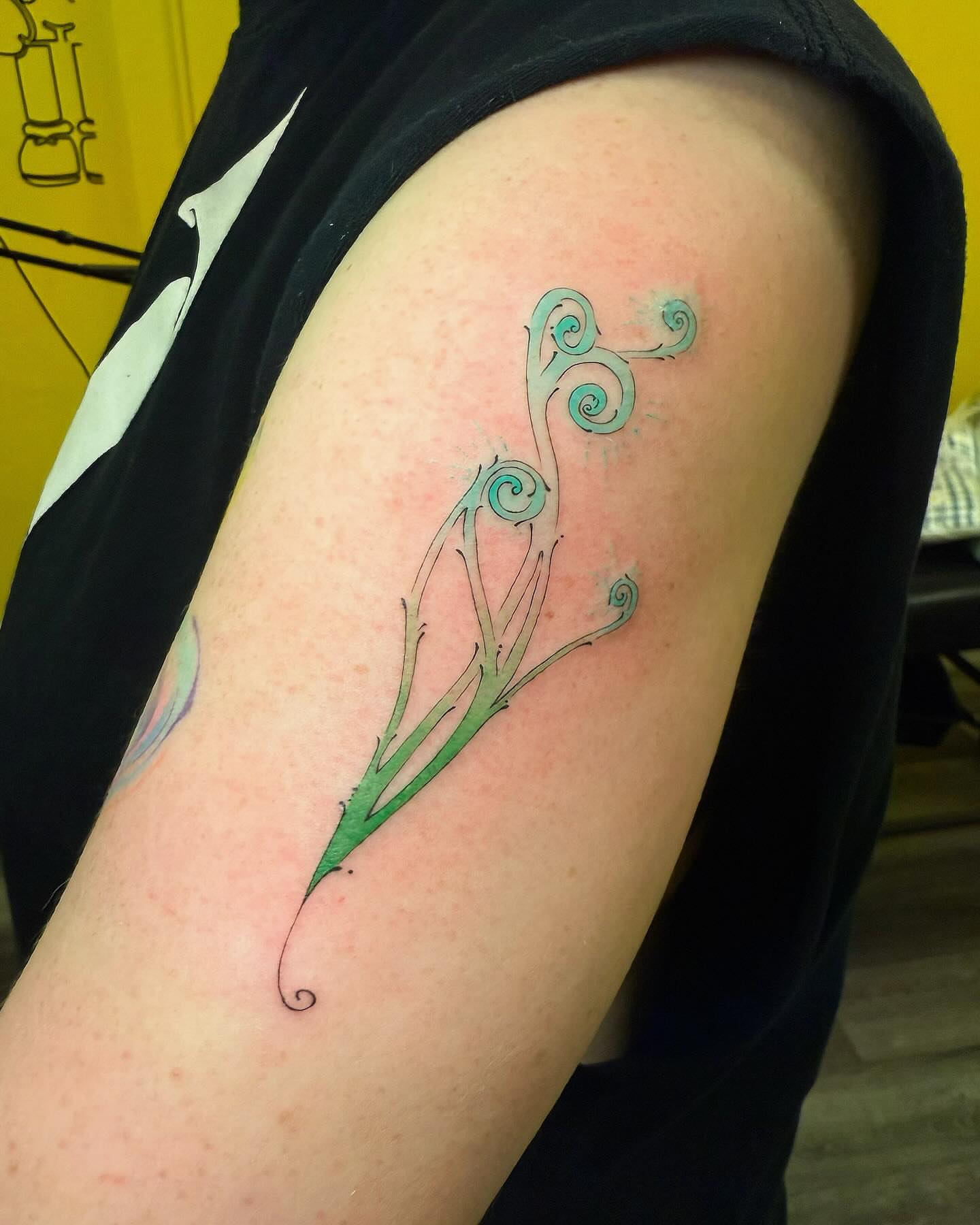 Fern watercolor tattoo on the upper arm by Echo