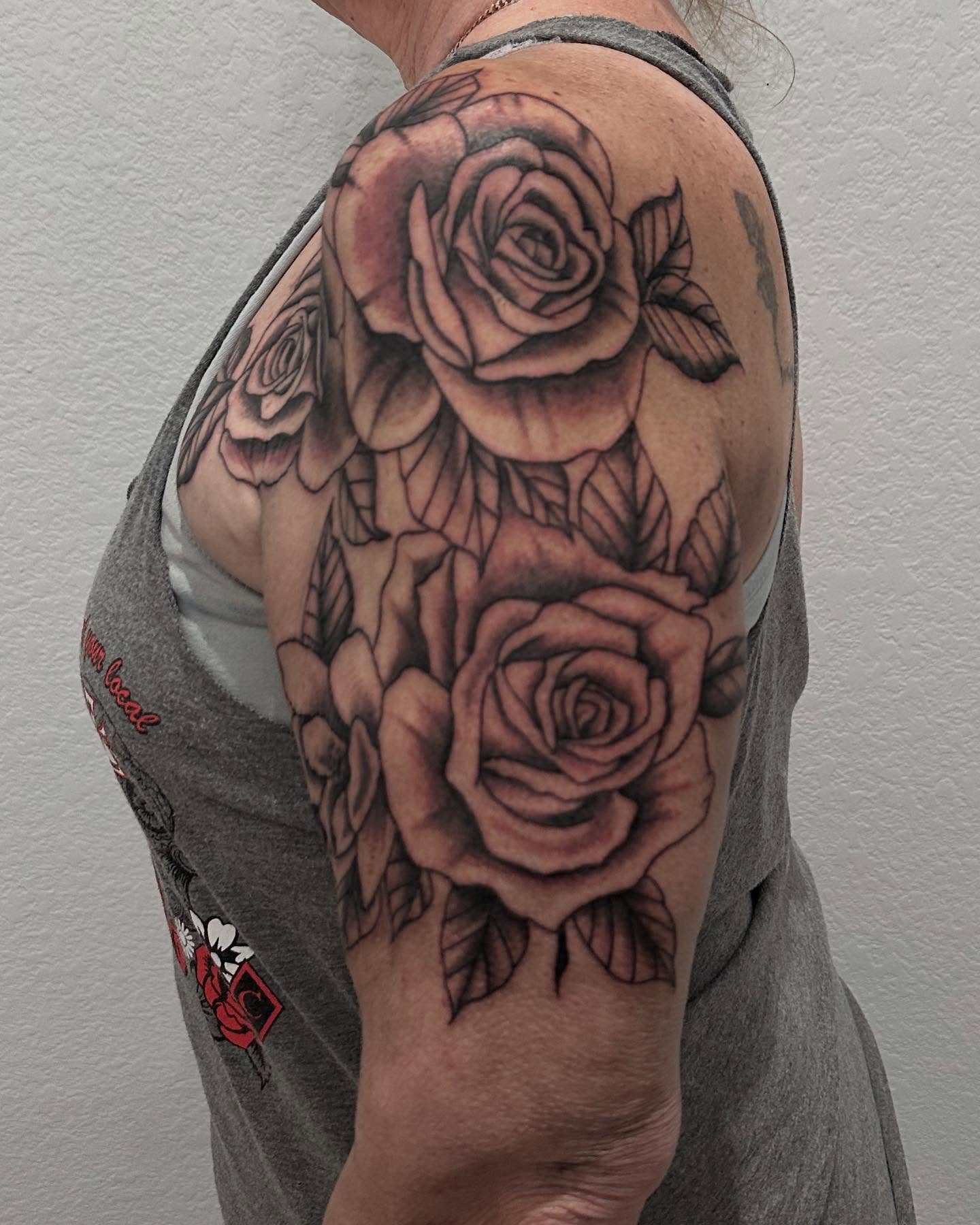 Roses realism tattoo on the upper arm by 𝕯𝖗𝖆𝕶𝖊㋛