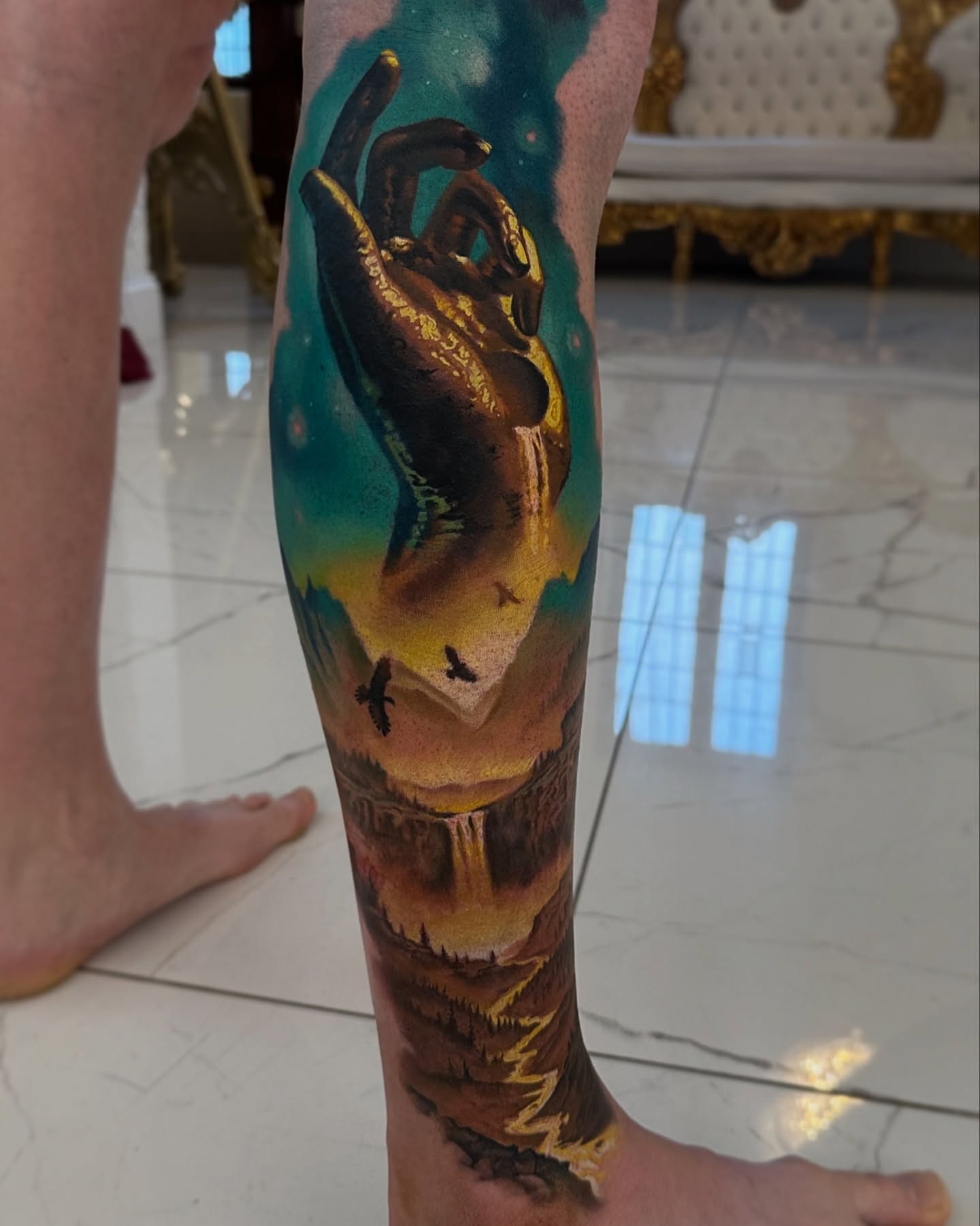 Landscape with hand reaching sky realism tattoo on the forearm by Jacob Sheffield, Grand Junction, Colorado