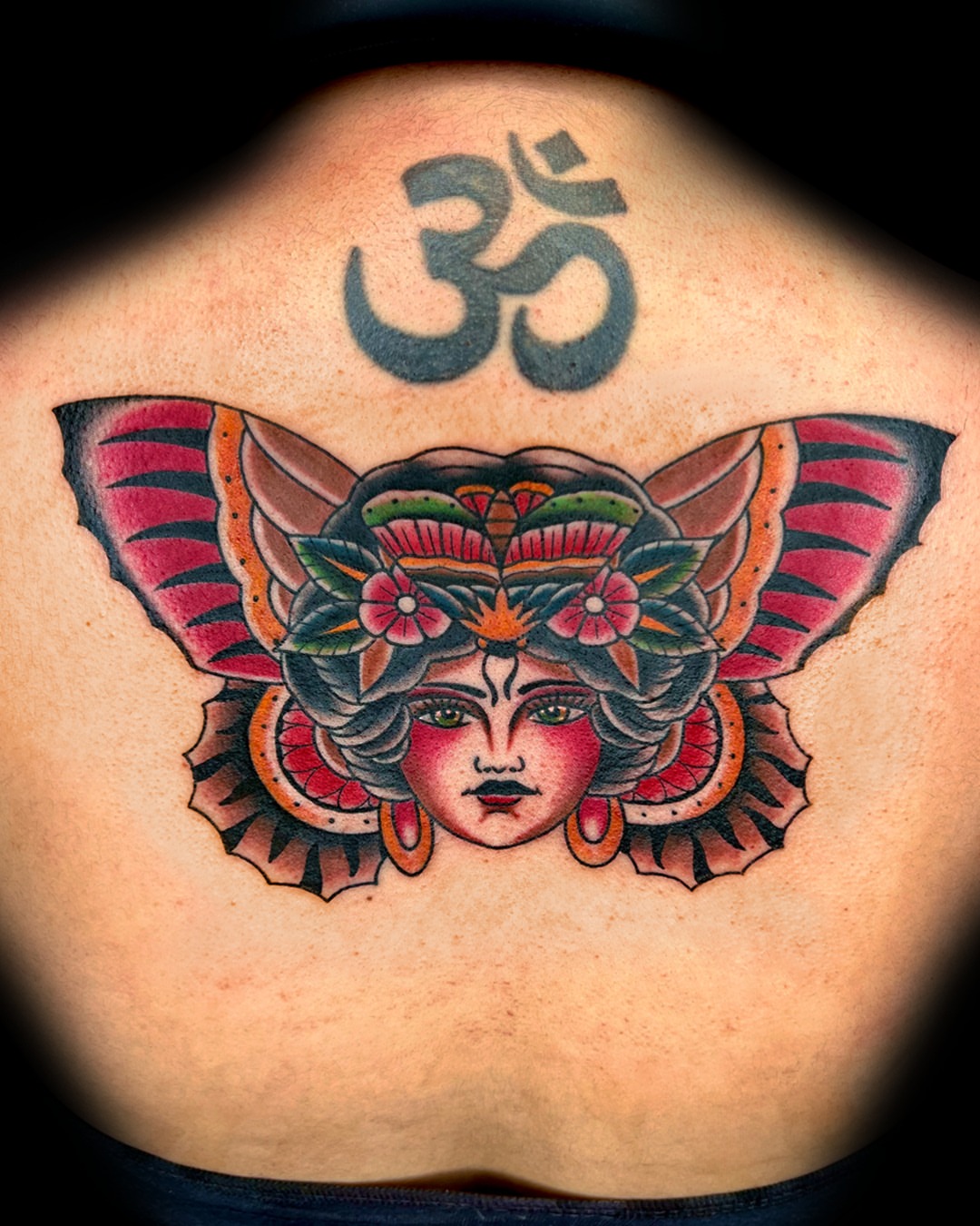 Woman's face with butterfly wings American traditional tattoo on the back by Massimiliano pennella