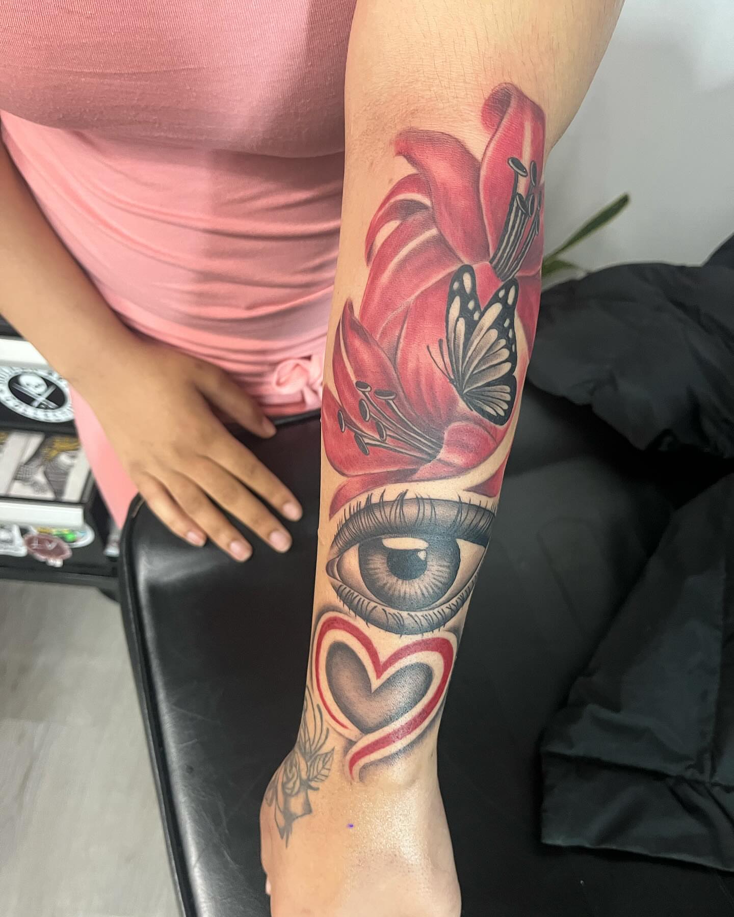Eye, flower, butterfly, heart realism tattoo on the forearm by Detroit Tattoo Artist