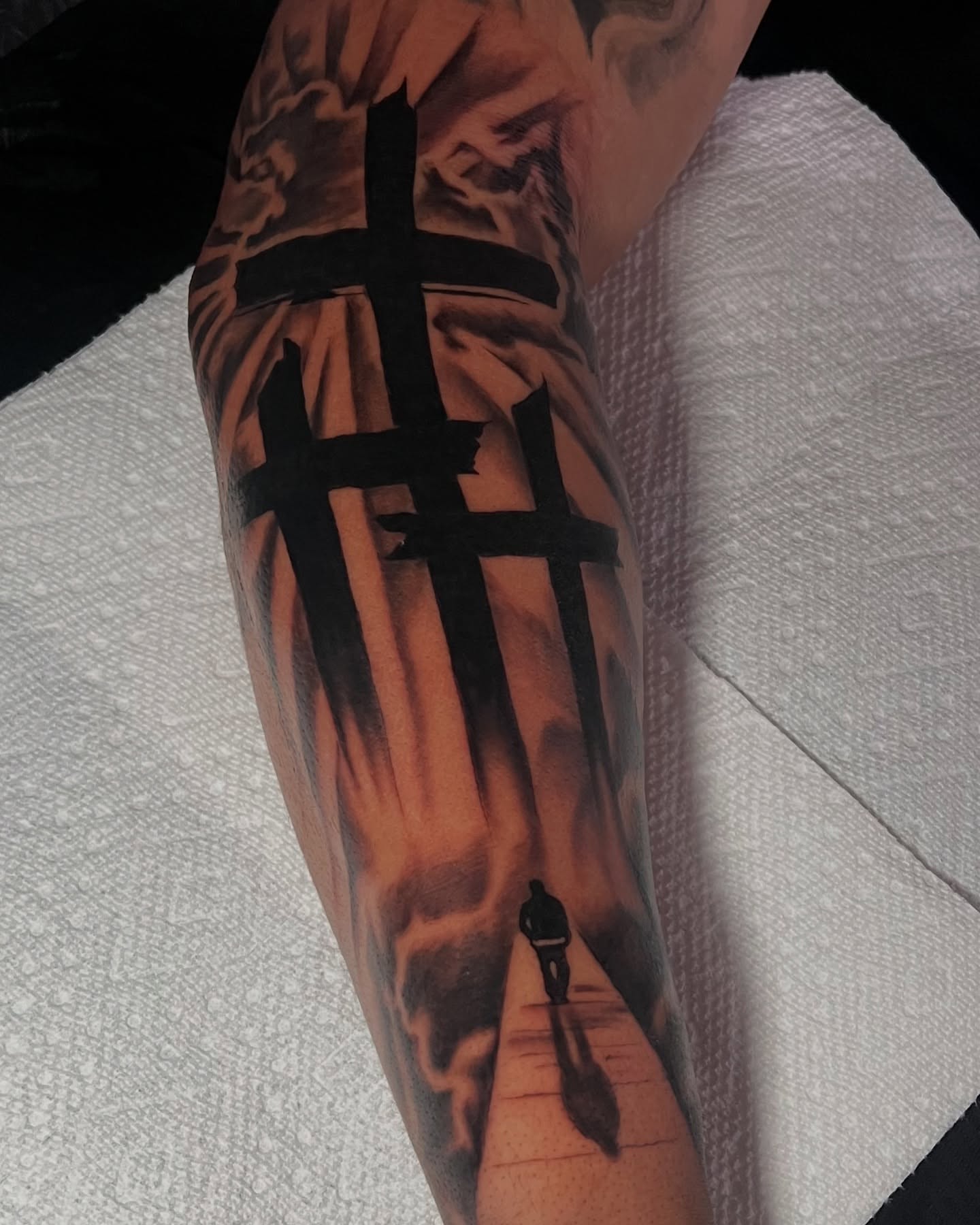 Cross and silhouette realism tattoo on the forearm by Moose