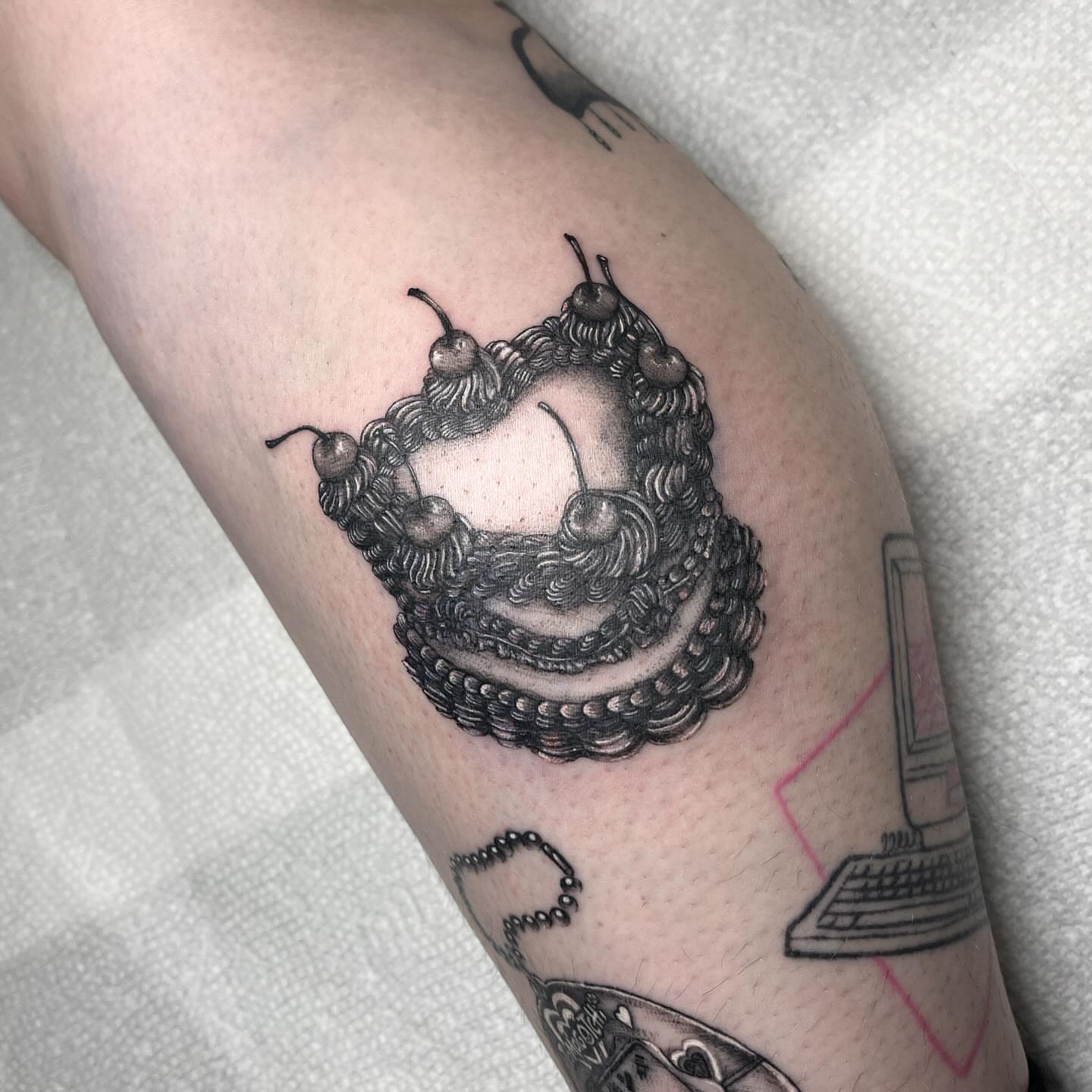 Cherry cake black and grey tattoo on the forearm by aurora