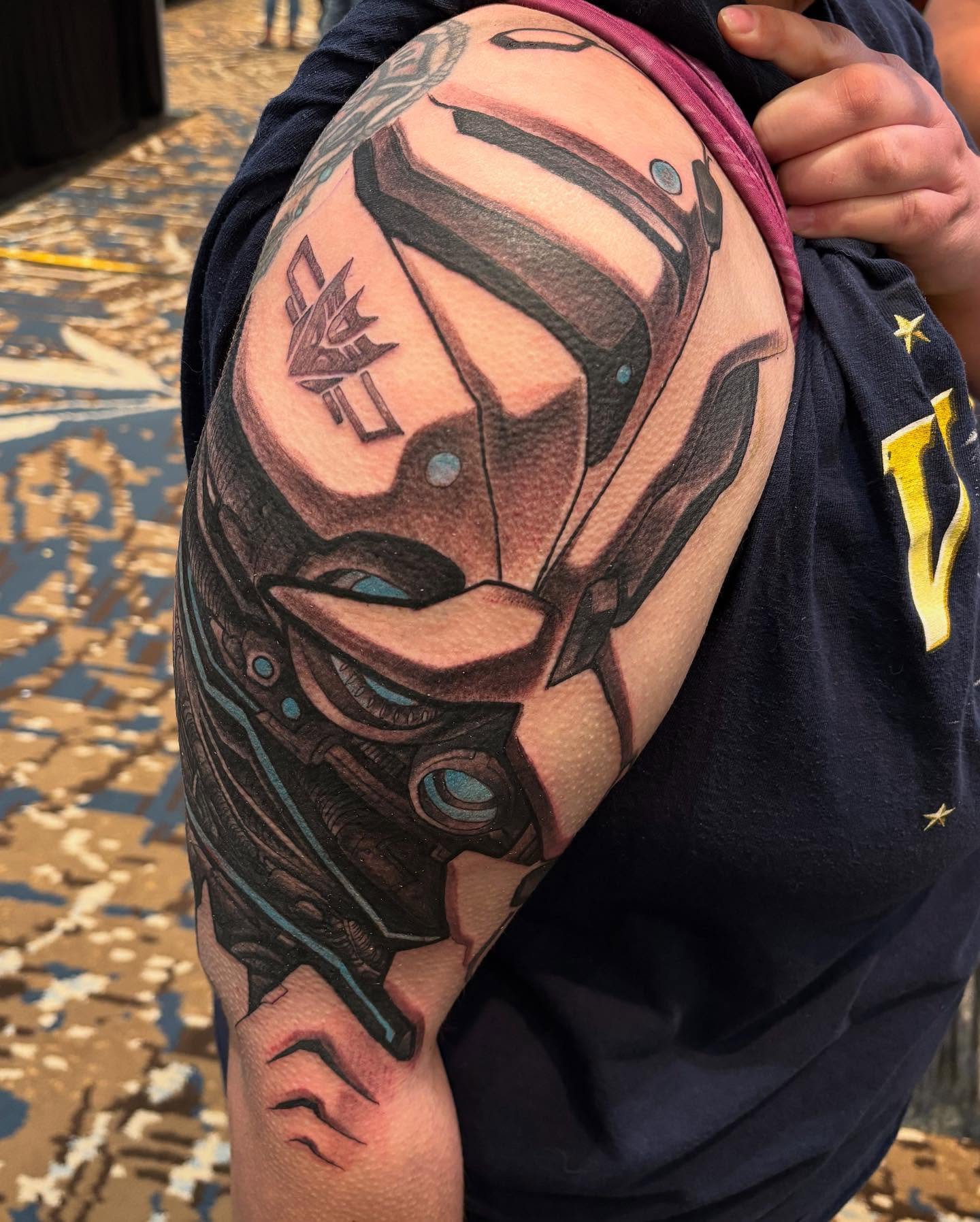 Mecha helmet realism tattoo on the shoulder by Rene Chavira