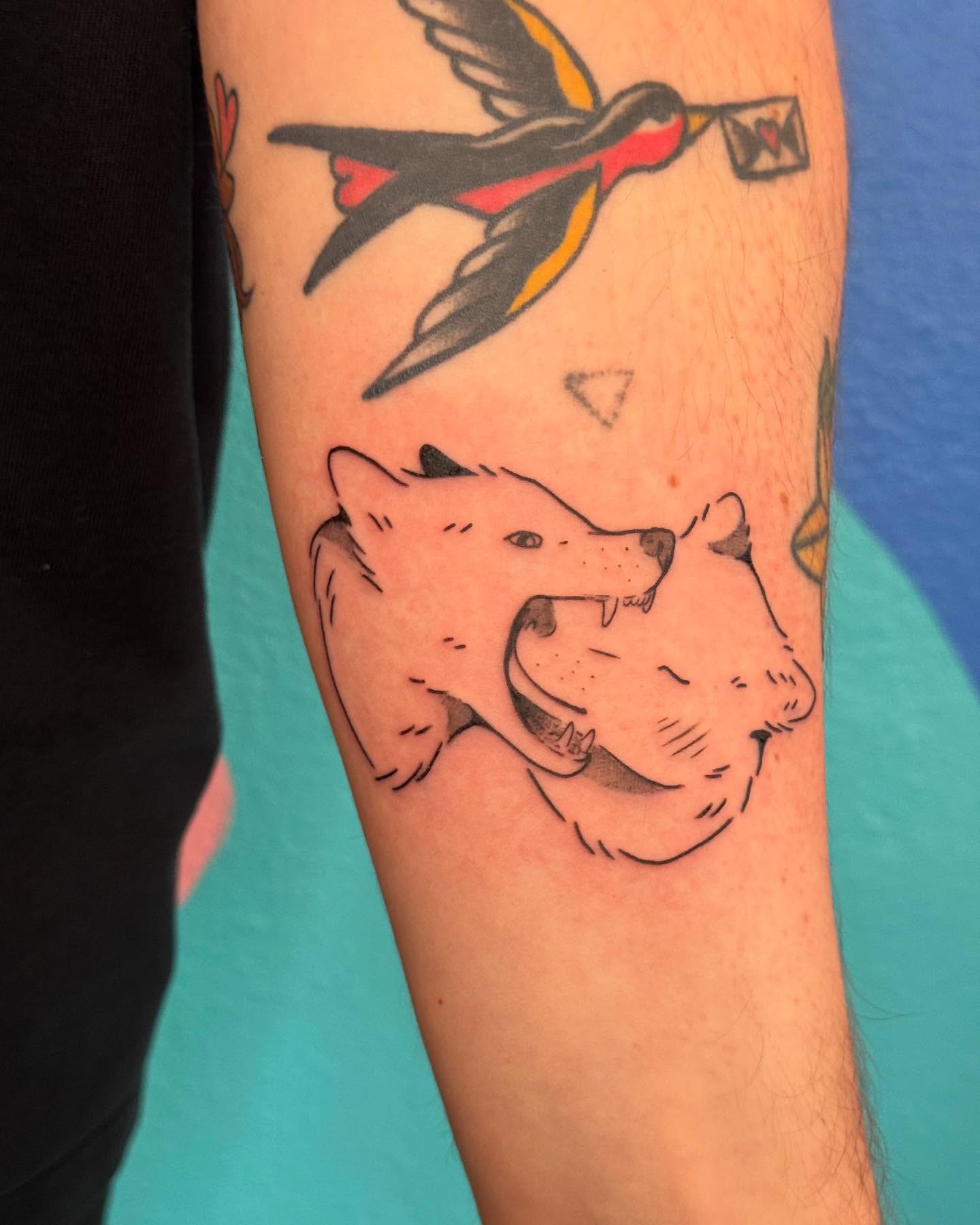 Wolves American traditional tattoo on the forearm by Ivy