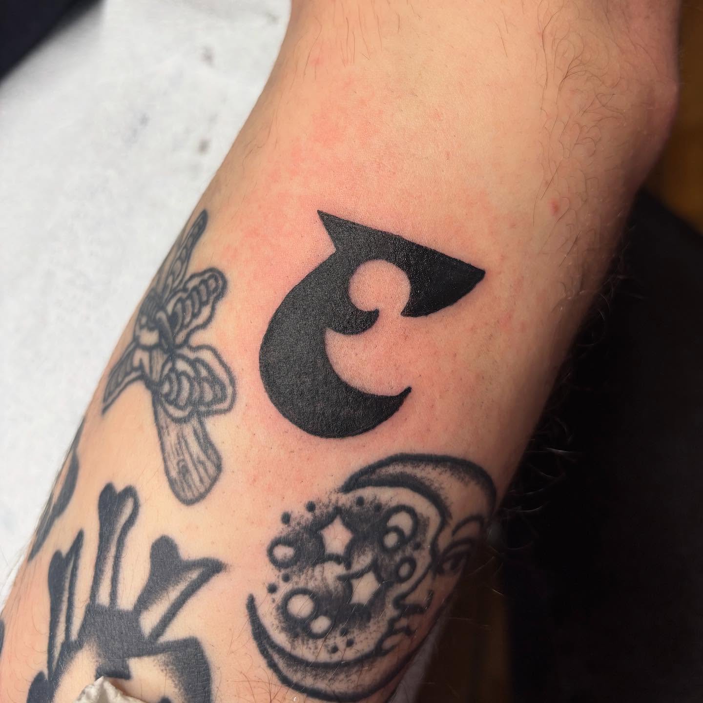 Abstract symbol black and grey tattoo on the forearm by Emmy Gallagher
