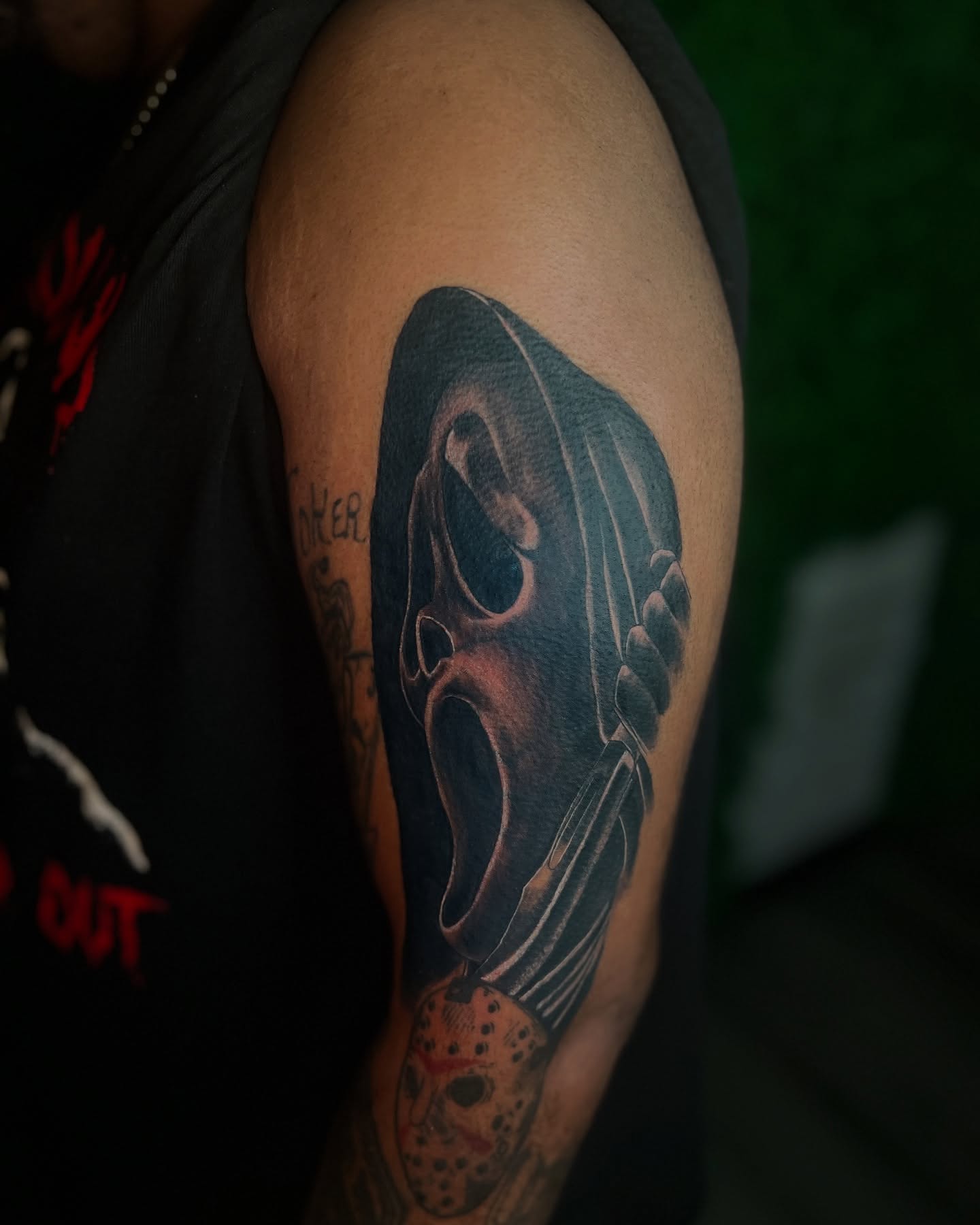 Mask and knife realism tattoo on the upper arm by Los Angeles Tattoo Artist