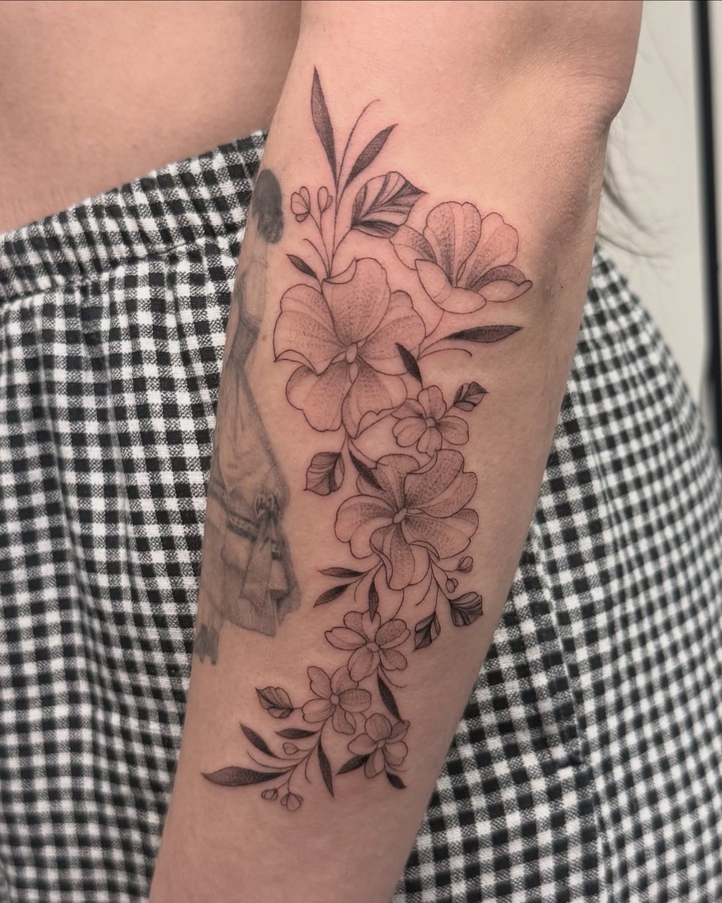 Floral bouquet black and grey tattoo on the forearm by liliana lopez