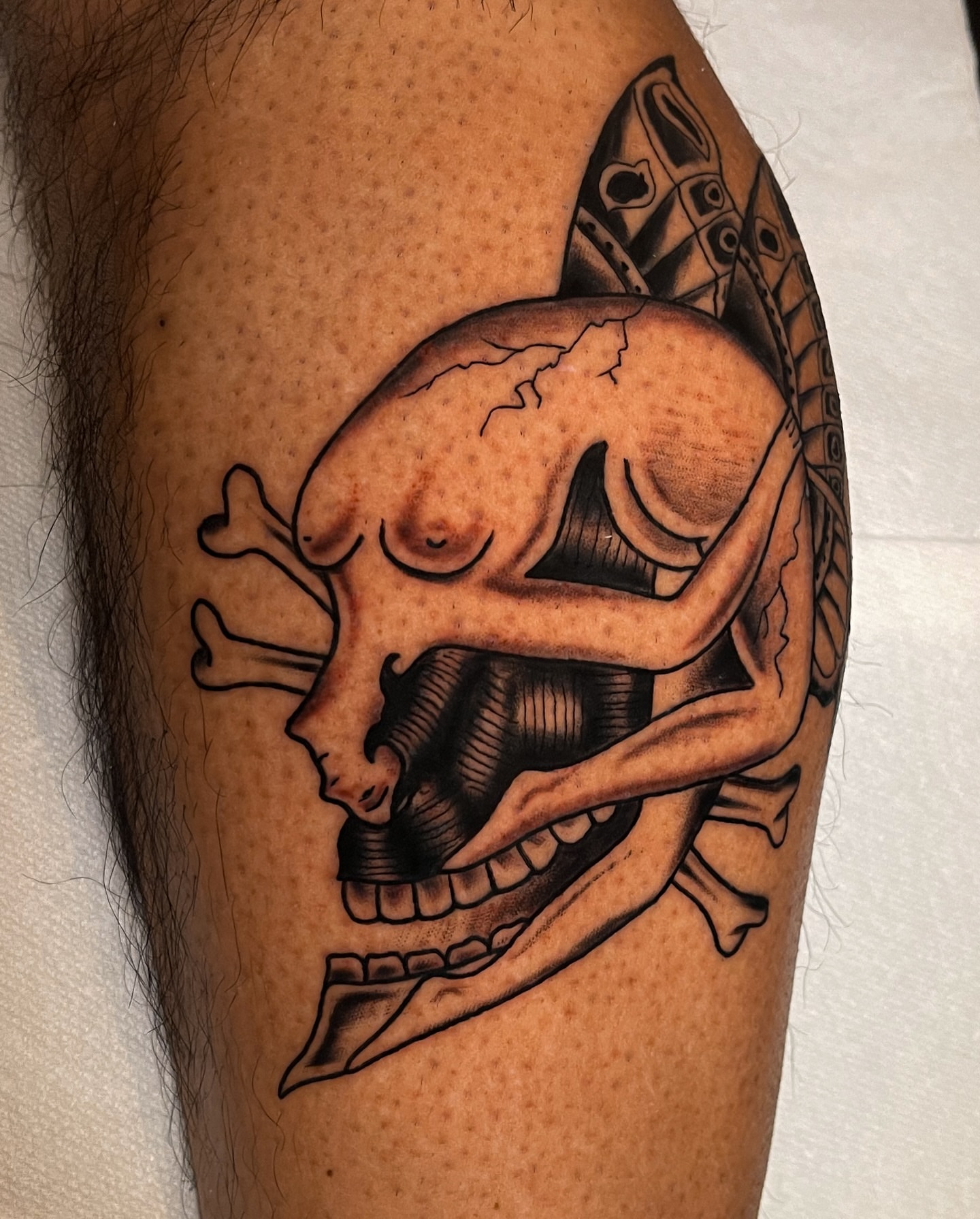 Skull and bones black and grey tattoo on the forearm by Miguel Henrik
