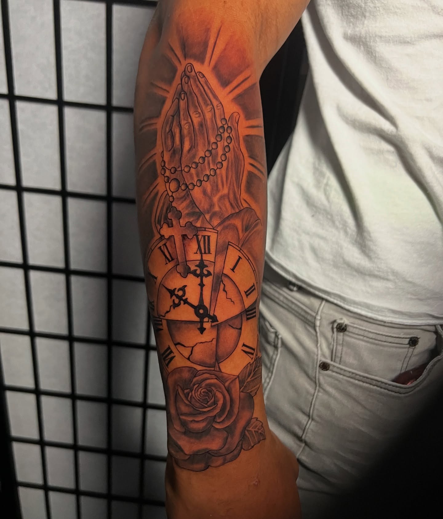 Praying hands with clock realism tattoo on the forearm by Baung Ben