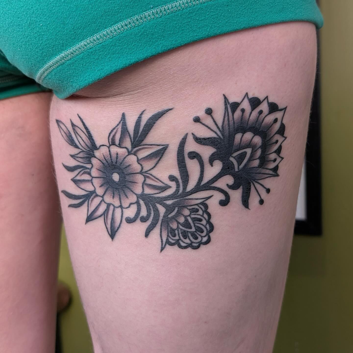 Floral design black and grey tattoo on the thigh by Jamie Yuu, Minneapolis, Minnesota