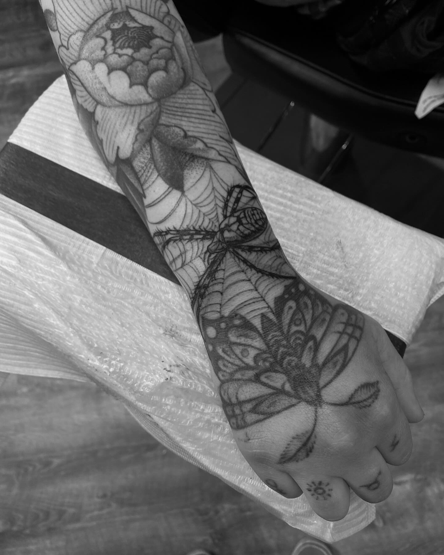 Butterfly and spider web realism tattoo on the forearm by Chase Skylar Clayton Ogle