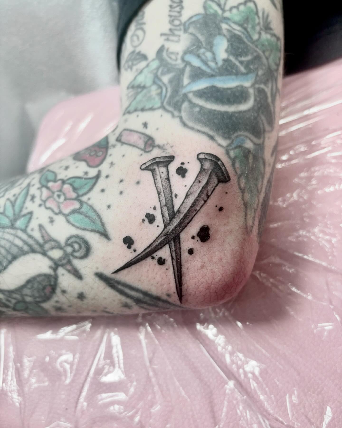 Crossed nails tattoo on the forearm by Zoe D