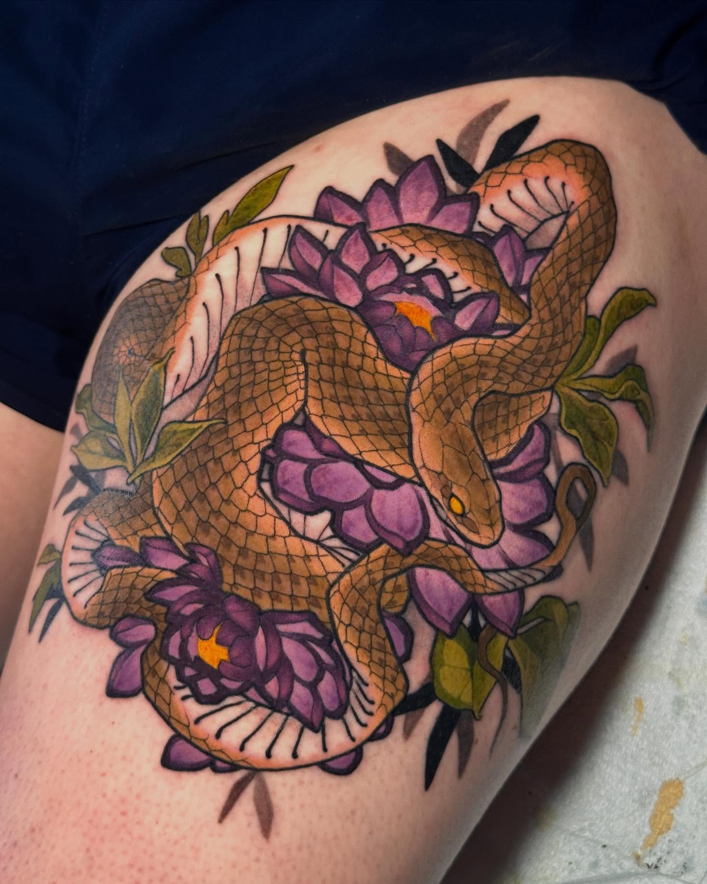 Snake and flowers American traditional tattoo on the thigh by Claire Evans, San Francisco, California