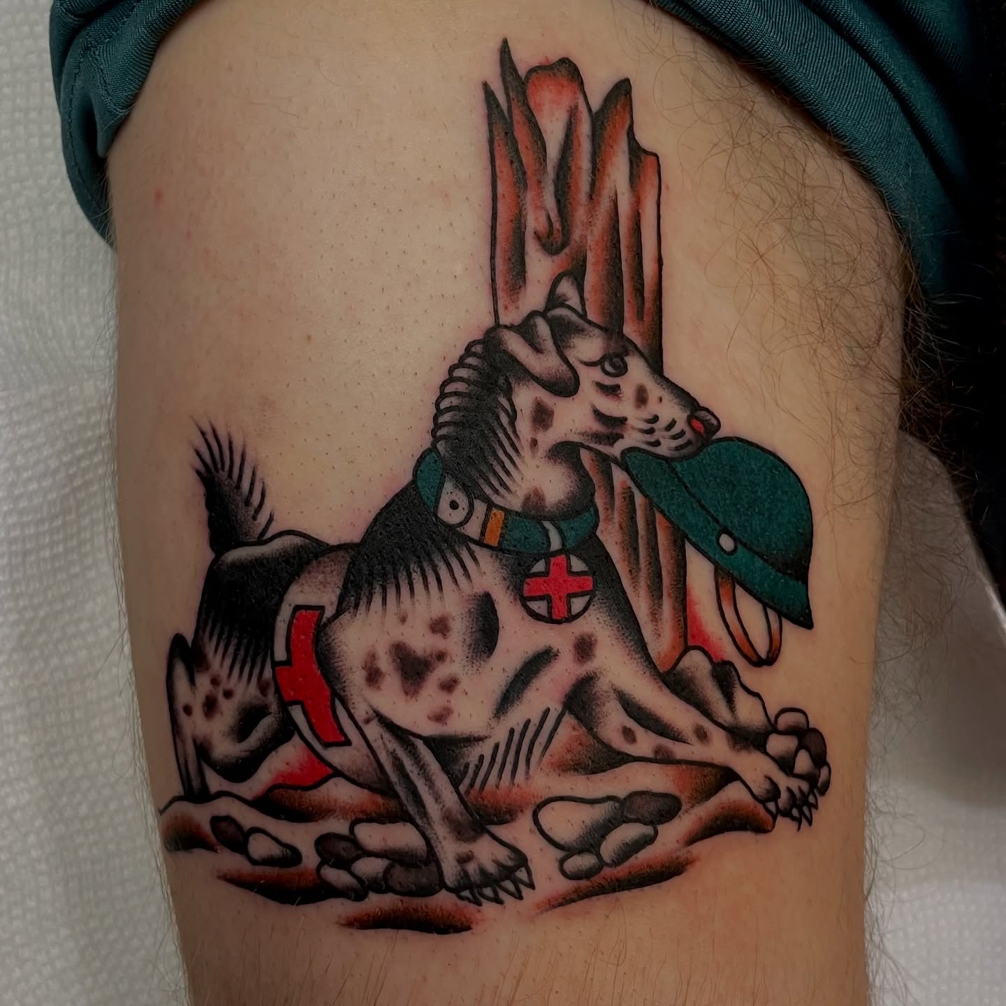 Dog with cross American traditional tattoo on the thigh by Texas Jonah