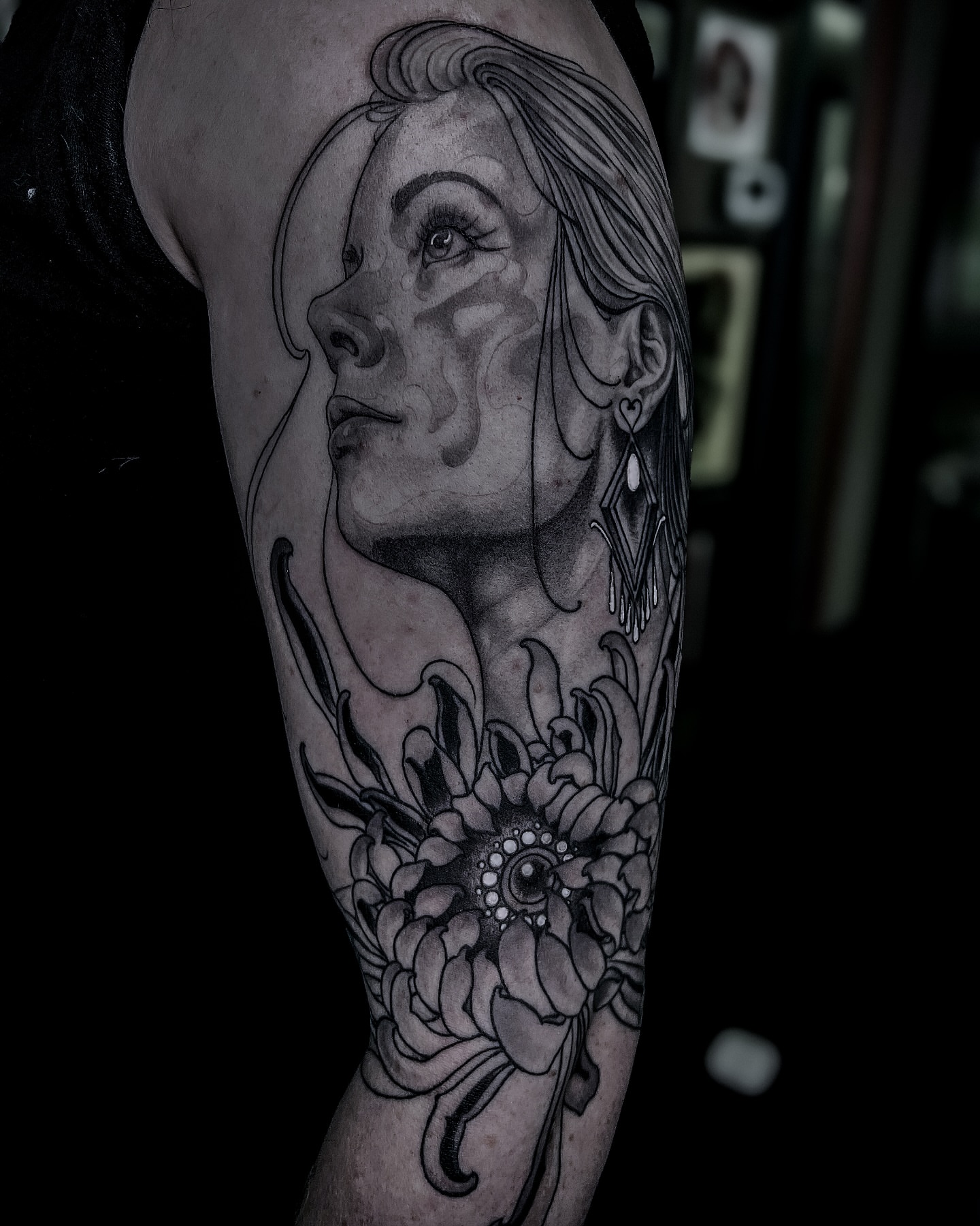 Woman's face with floral elements realism tattoo on the forearm by Lorenzo Gomez, San Diego, California