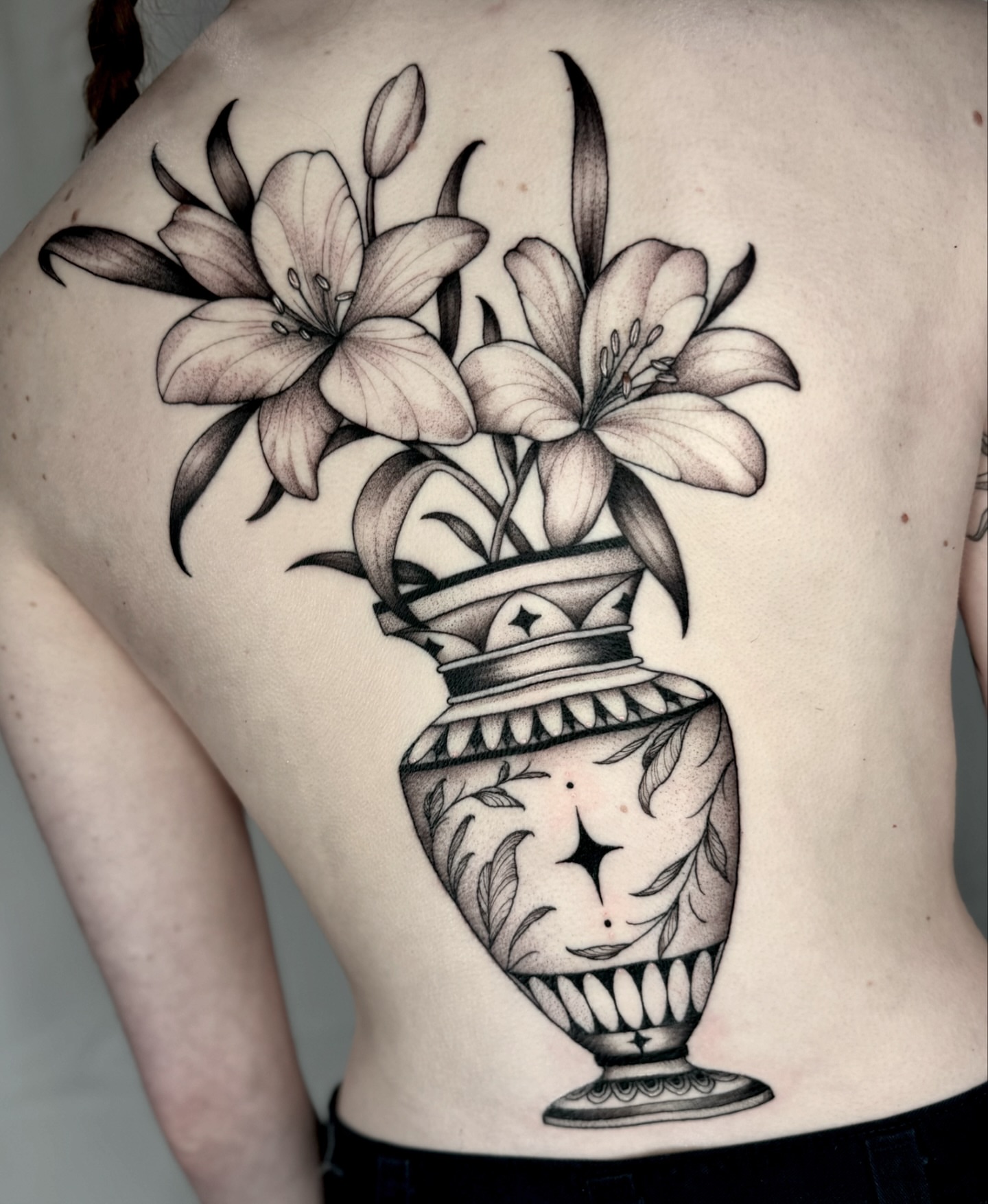 Lilies in vase realism tattoo on the back by Kathryn Semus