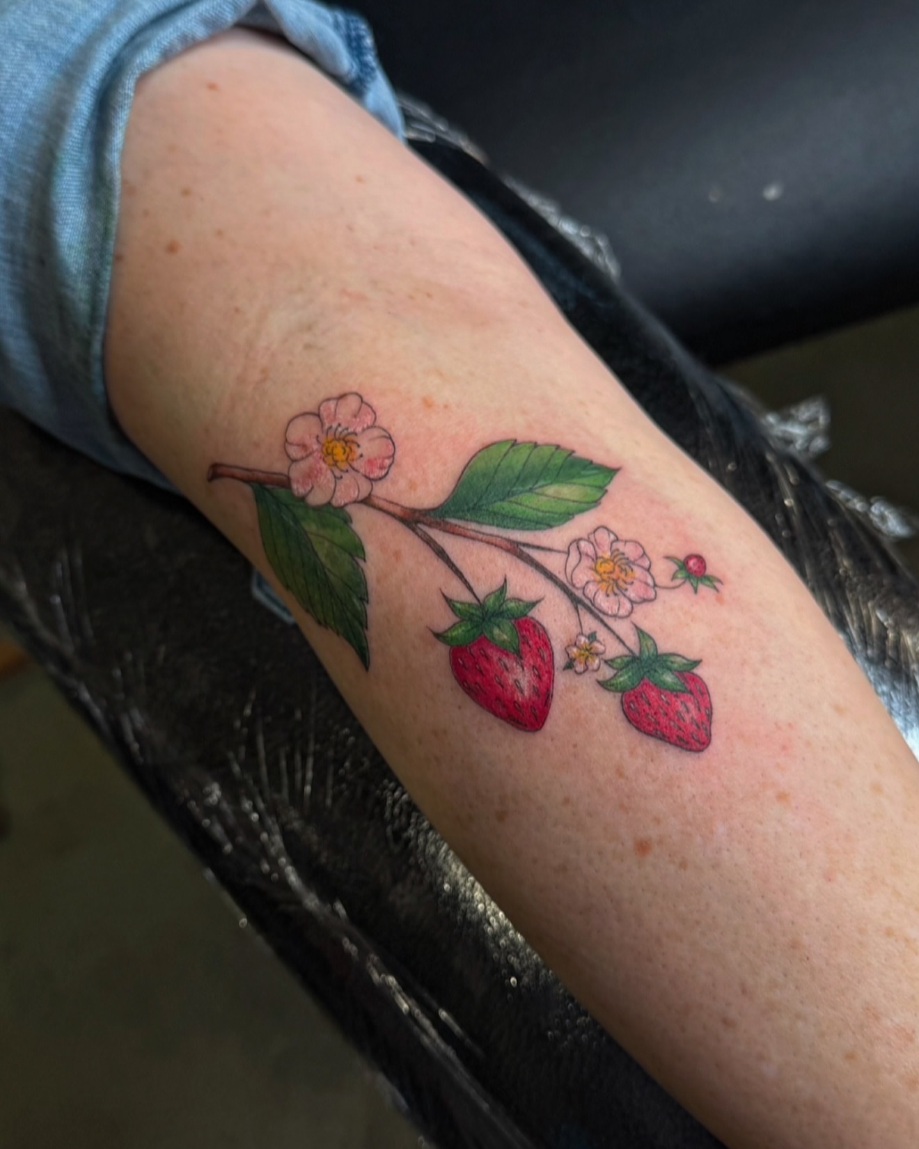 Strawberry branch with flowers realism tattoo on the forearm by Dee, San Diego, California
