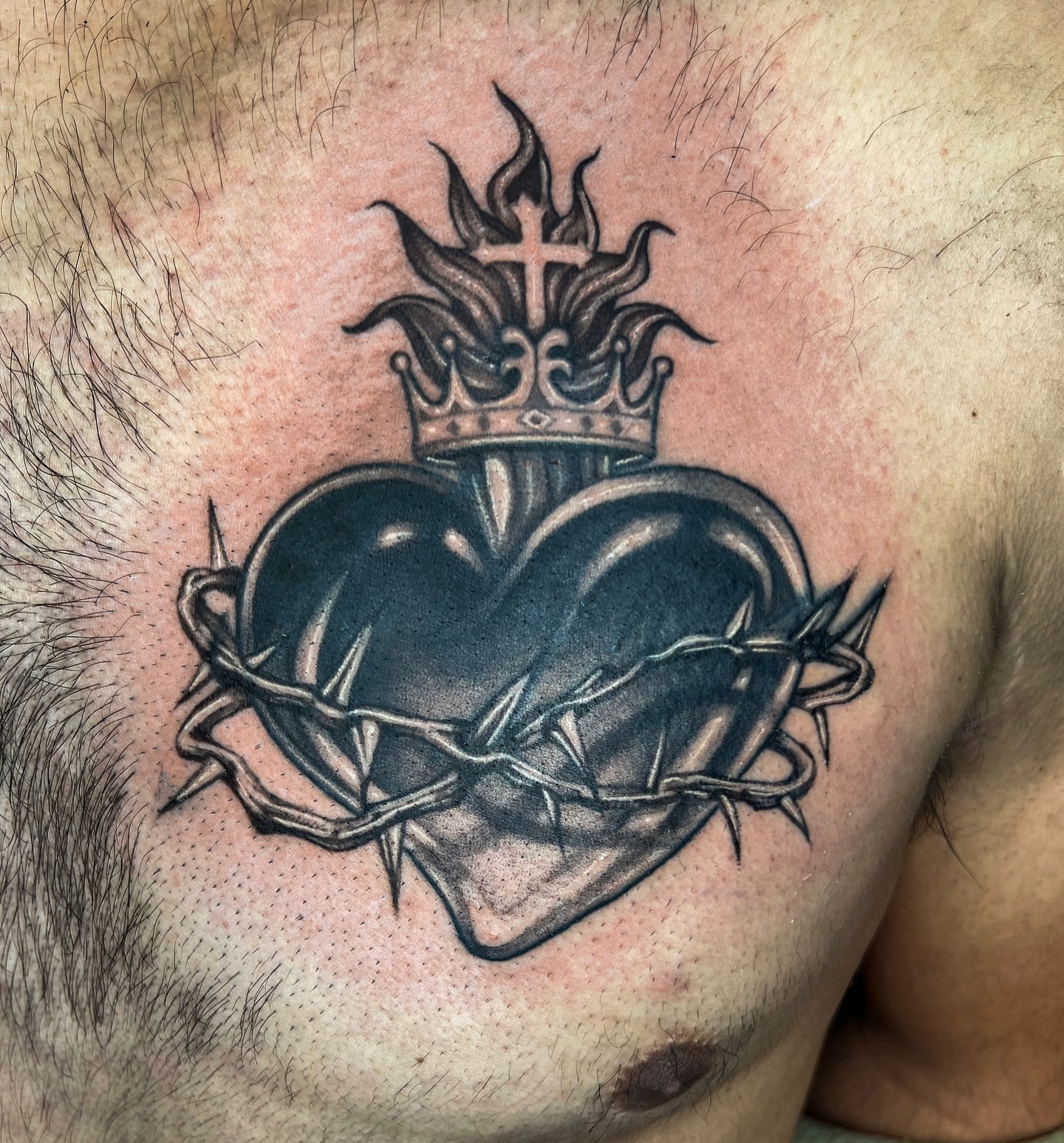 Heart with crown and thorns black and grey tattoo on the chest by Jordyn Tinney