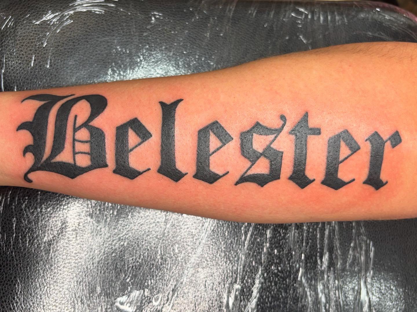 Belester lettering script tattoo on the forearm by Oscar Cuéllar (Kue-Yar)