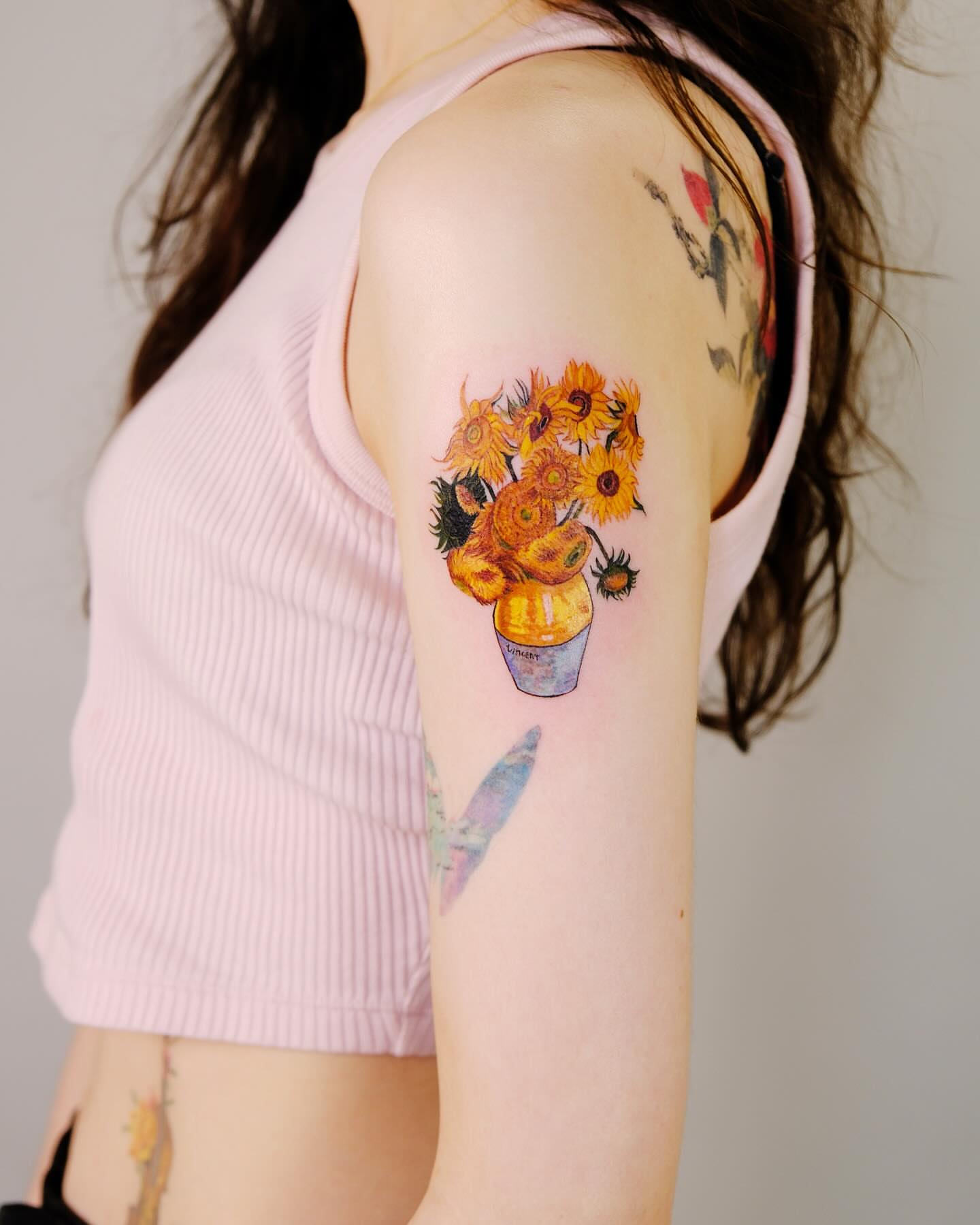 Sunflowers watercolor tattoo on the upper arm by Yeye