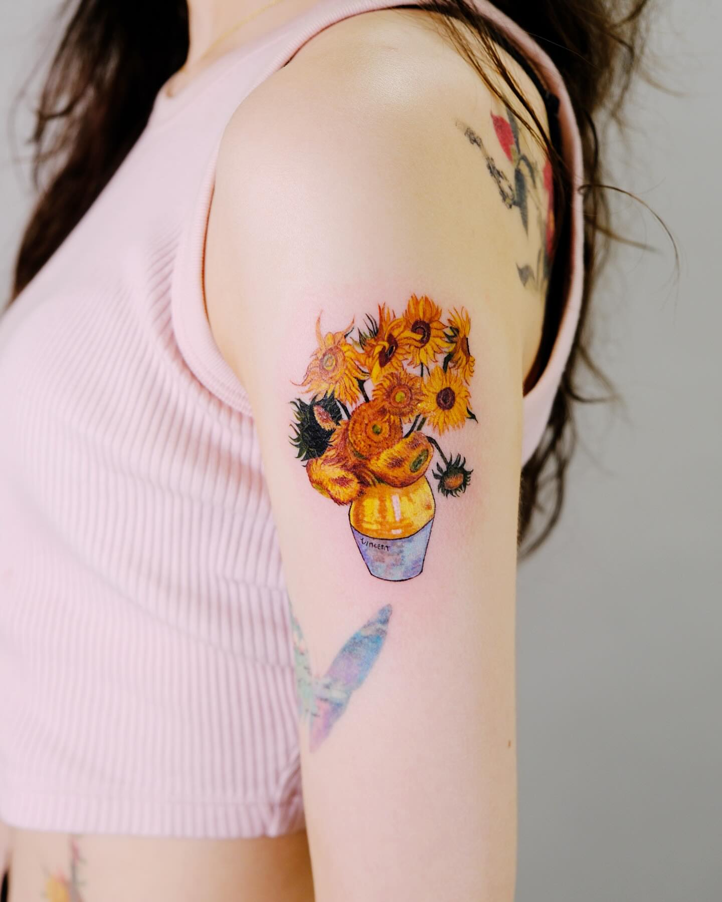 Sunflowers realism tattoo on the upper arm by Yeye