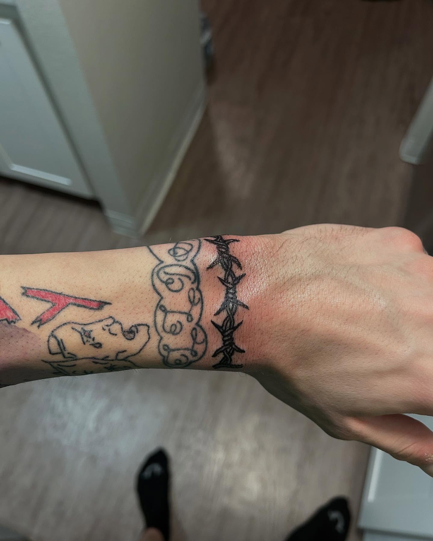 Barbed wire and script black and grey tattoo on the forearm by 702tattoo💉🩸