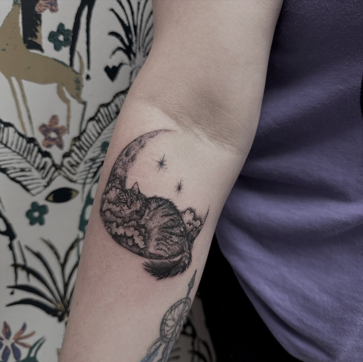Cat sleeping under moon realism tattoo on the forearm by Syd Cheyenne