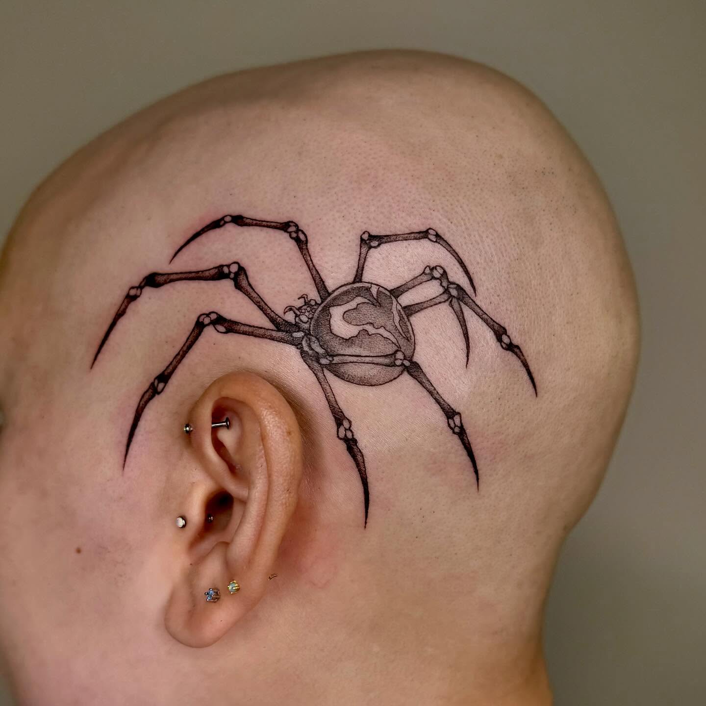 Spider black and grey tattoo on the head by taline