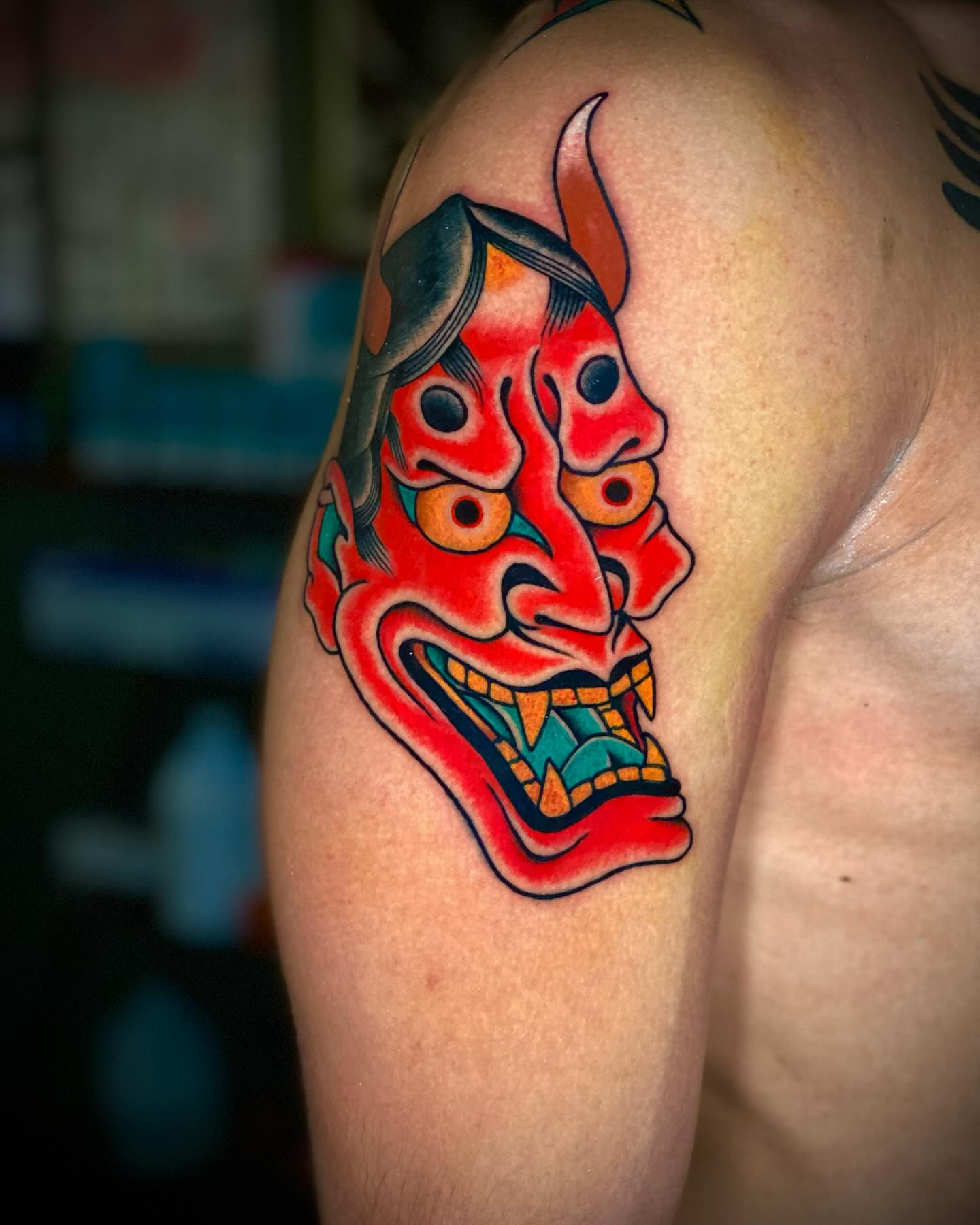 Demon mask American traditional tattoo on the shoulder by Alex Muniz