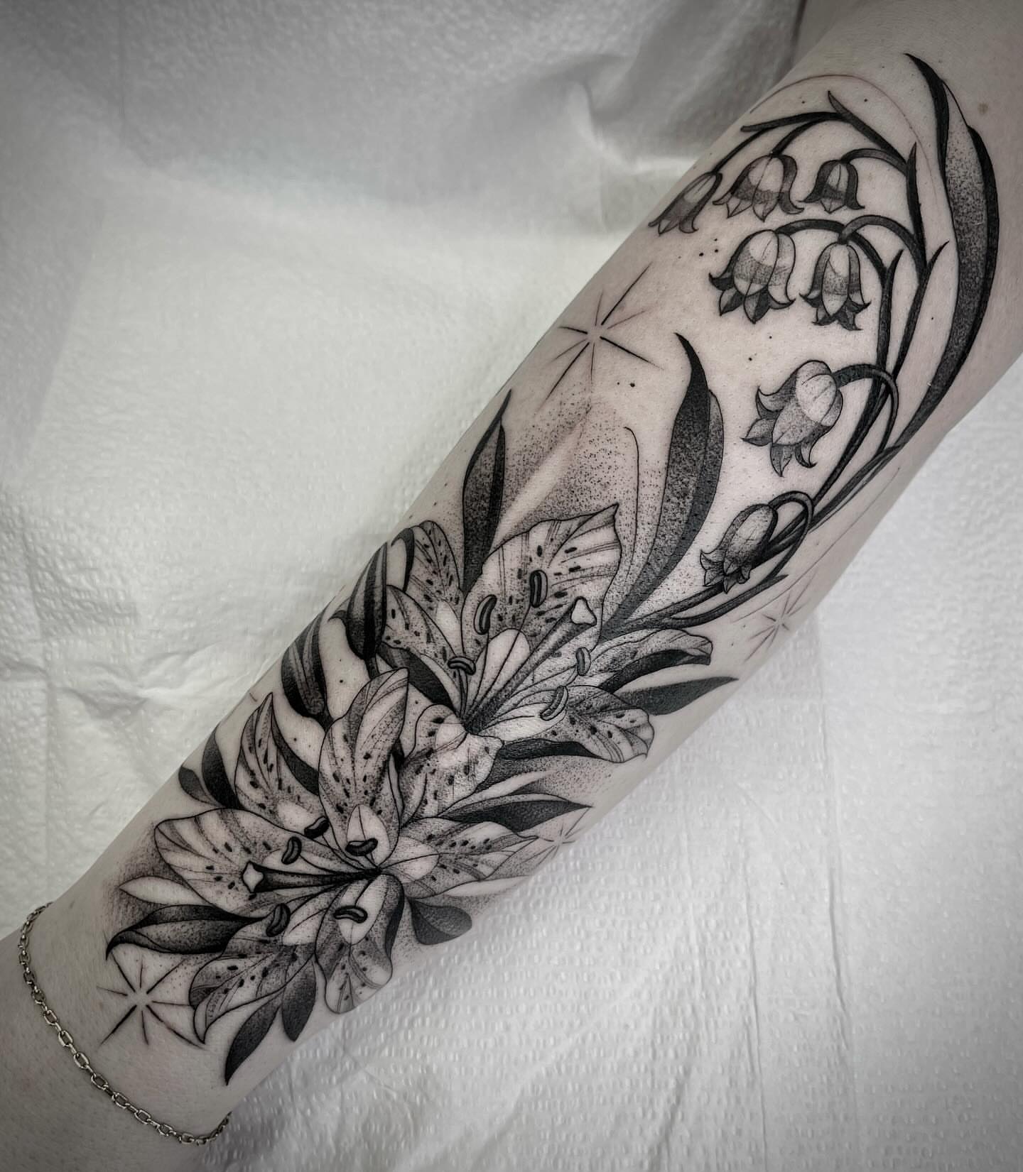 Lilies and bellflowers dotwork tattoo on the forearm by Martha Gual π€ East ATX Tattooer