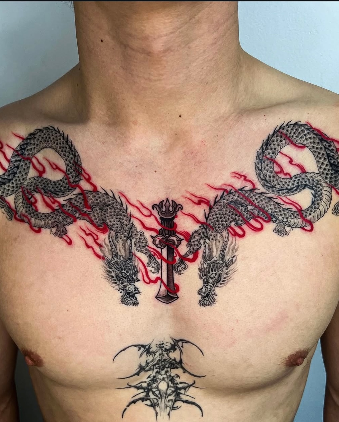 Dragons and sword black and grey tattoo on the chest by Swani