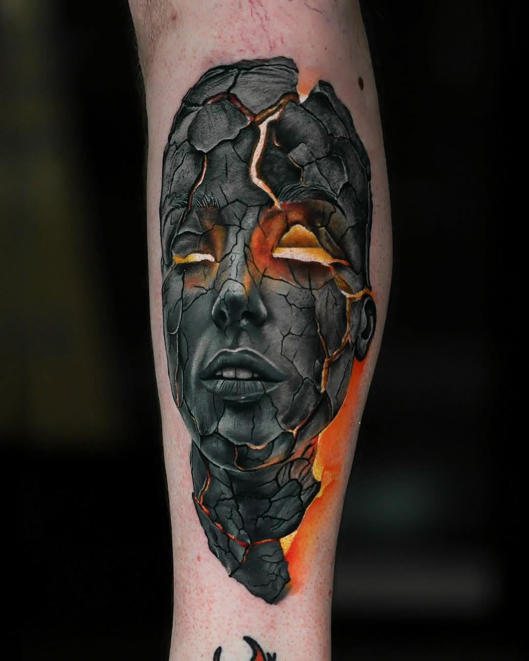 Cracked face with glowing embers surrealism tattoo on the forearm by Felipe Andrade