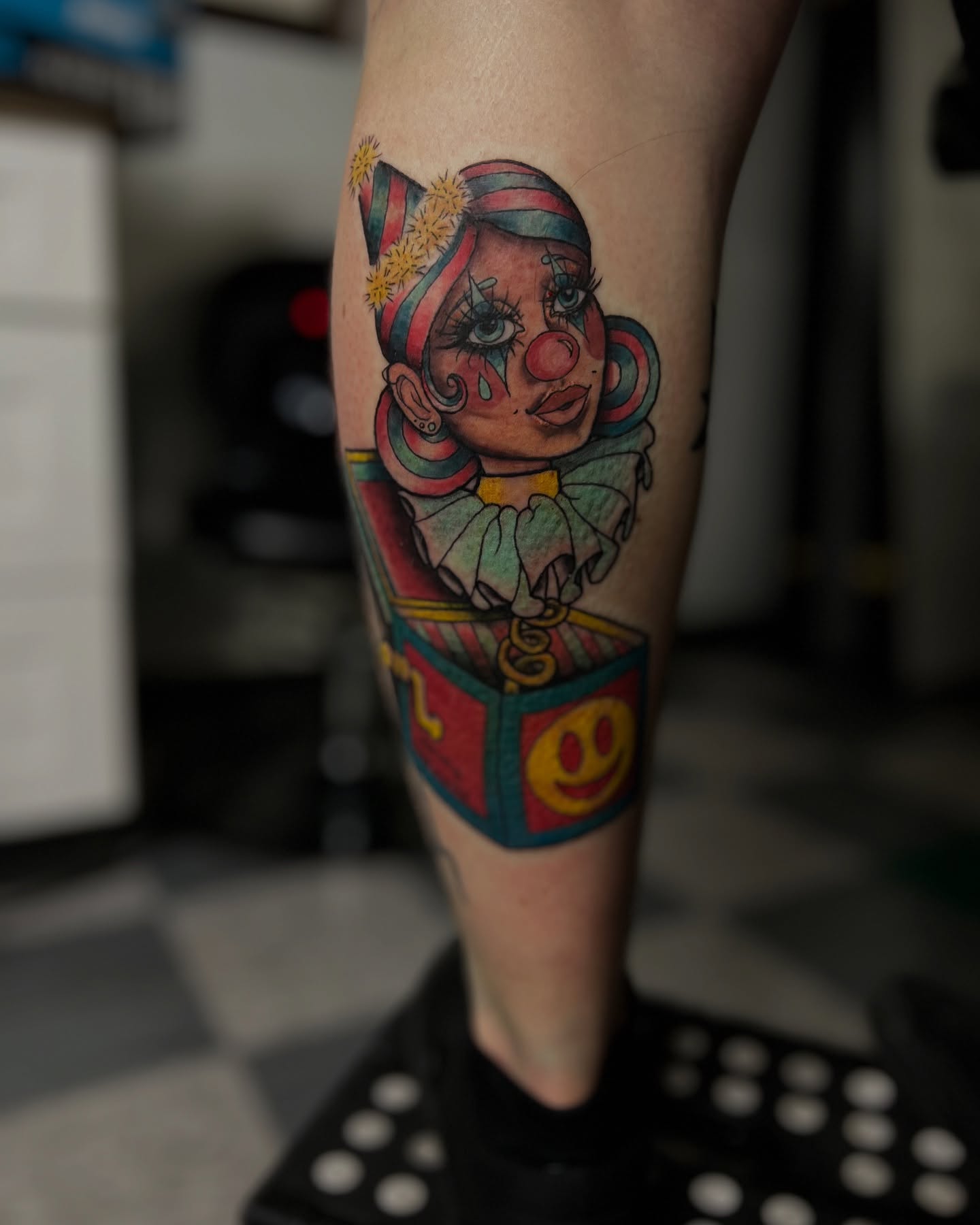 Clown in jack-in-the-box American traditional tattoo on the forearm by Stevie Reign