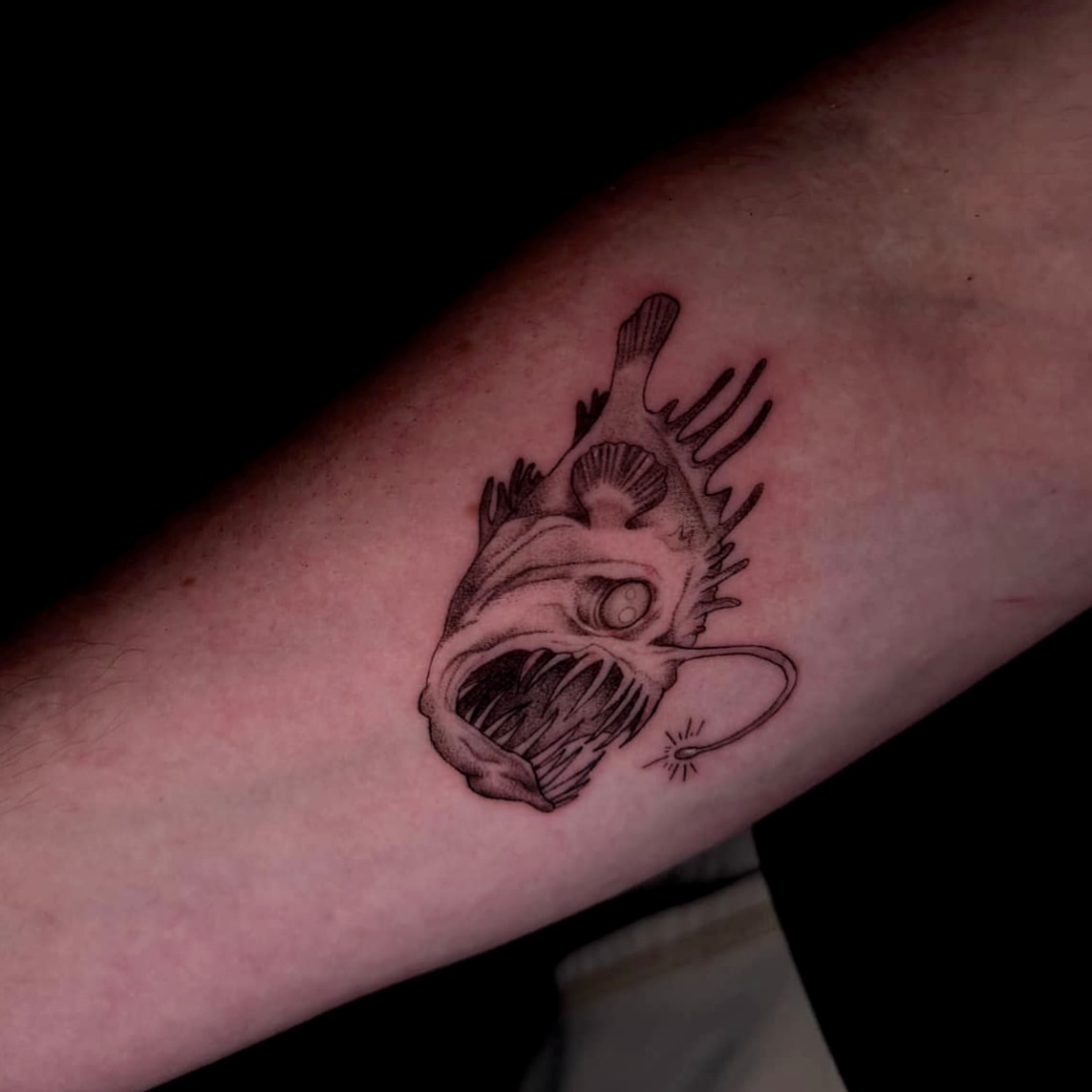 Angler fish black and grey tattoo on the forearm by V