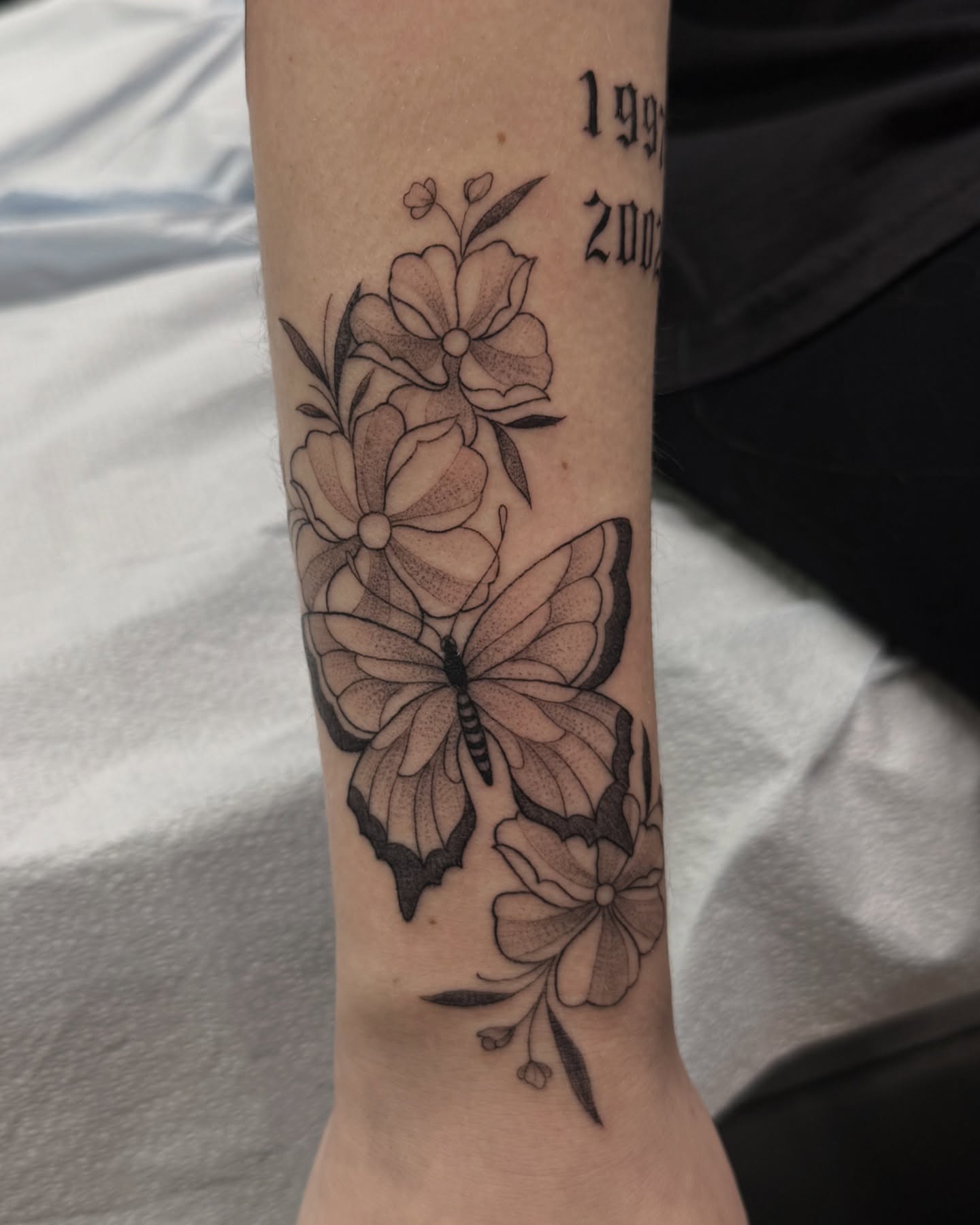Butterfly and flowers dotwork tattoo on the forearm by liliana lopez
