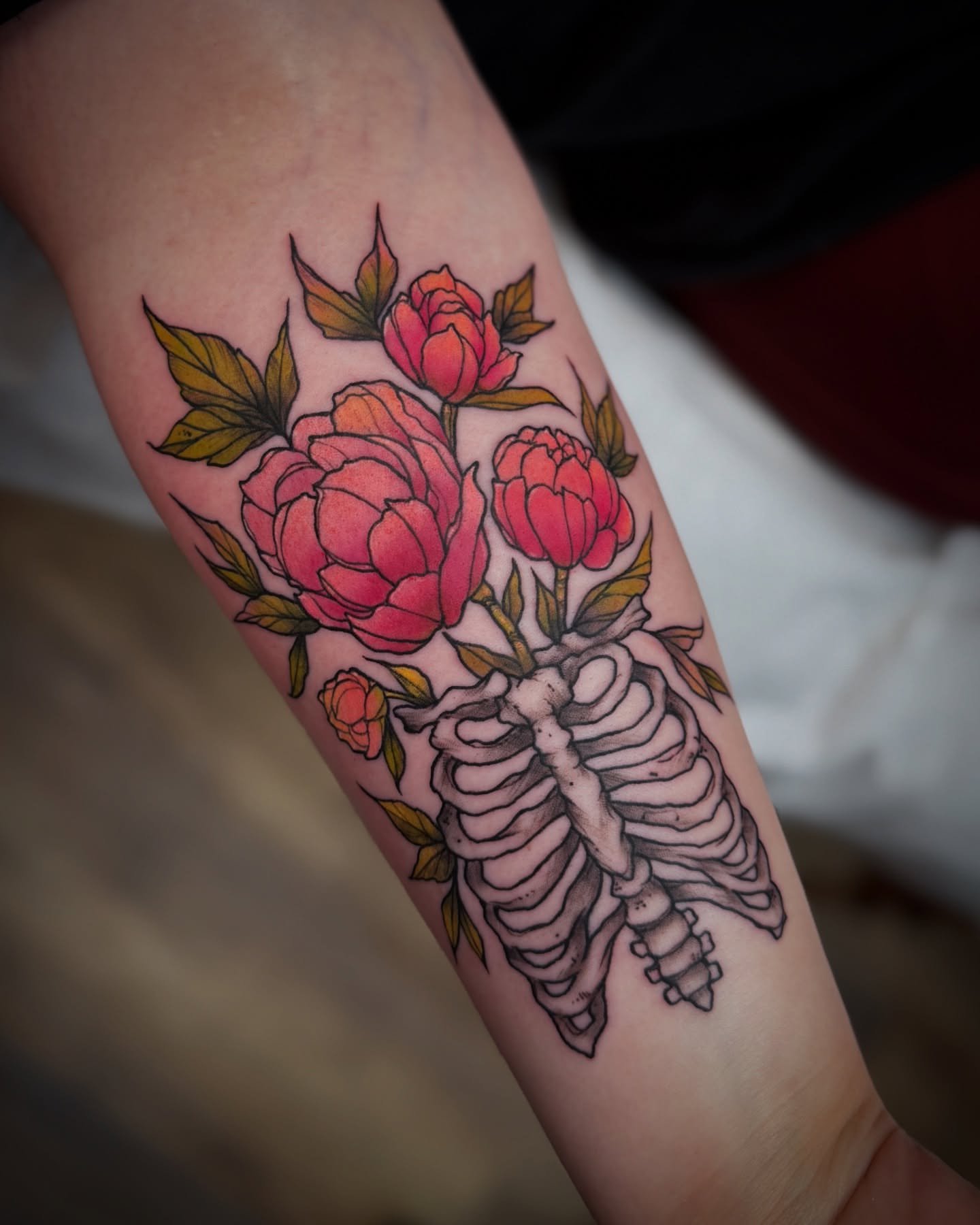 Peony bouquet and ribcage American traditional tattoo on the forearm by Michael Langdale