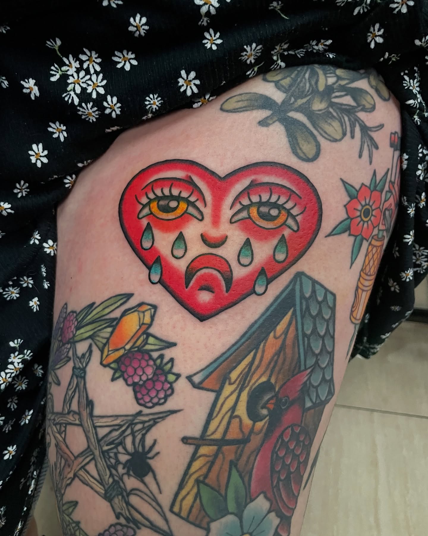 Heart with face American traditional tattoo on the thigh by Candence Smith